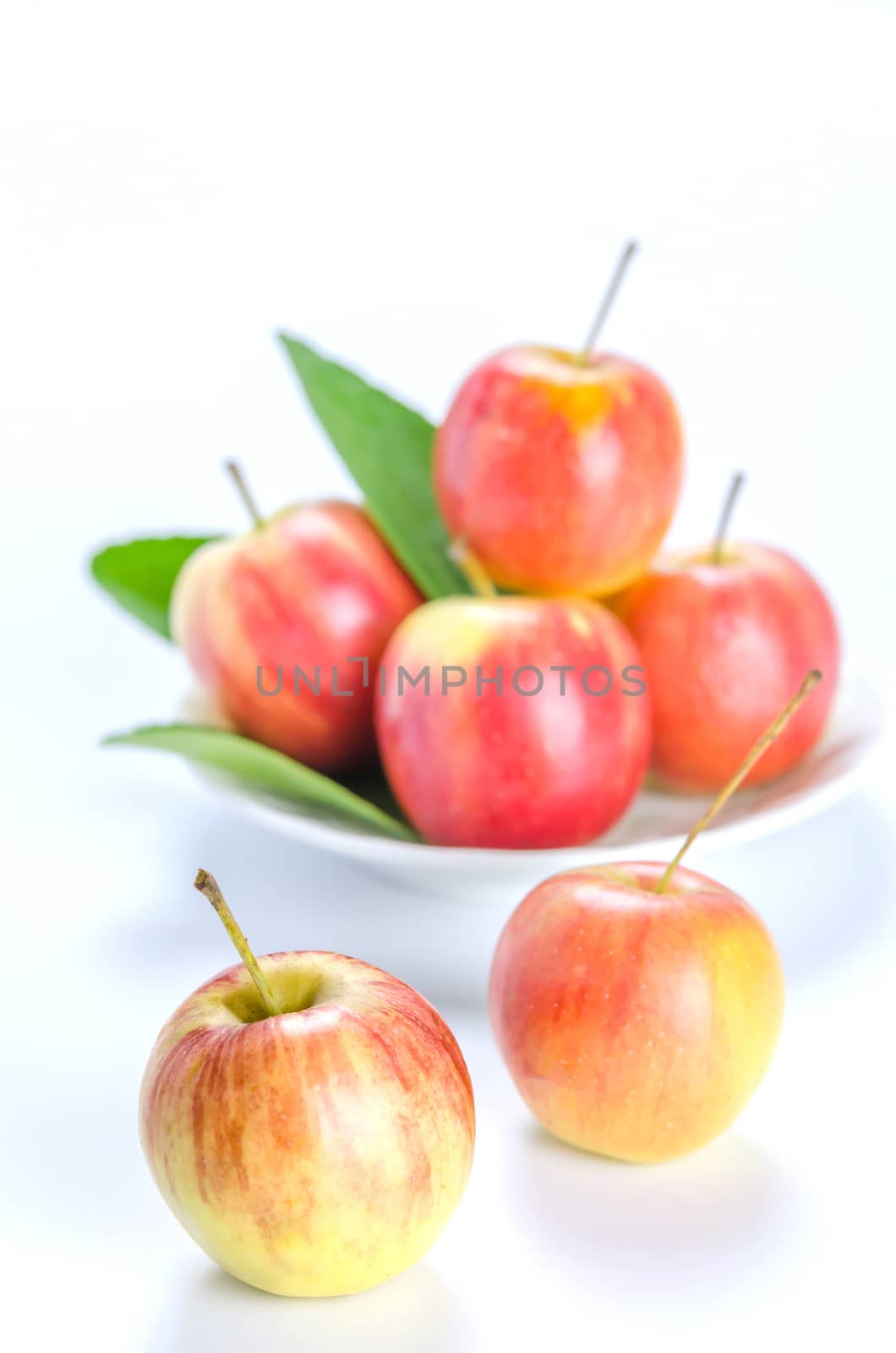 Red and yellow apple with white bowl , organic fresh fruit