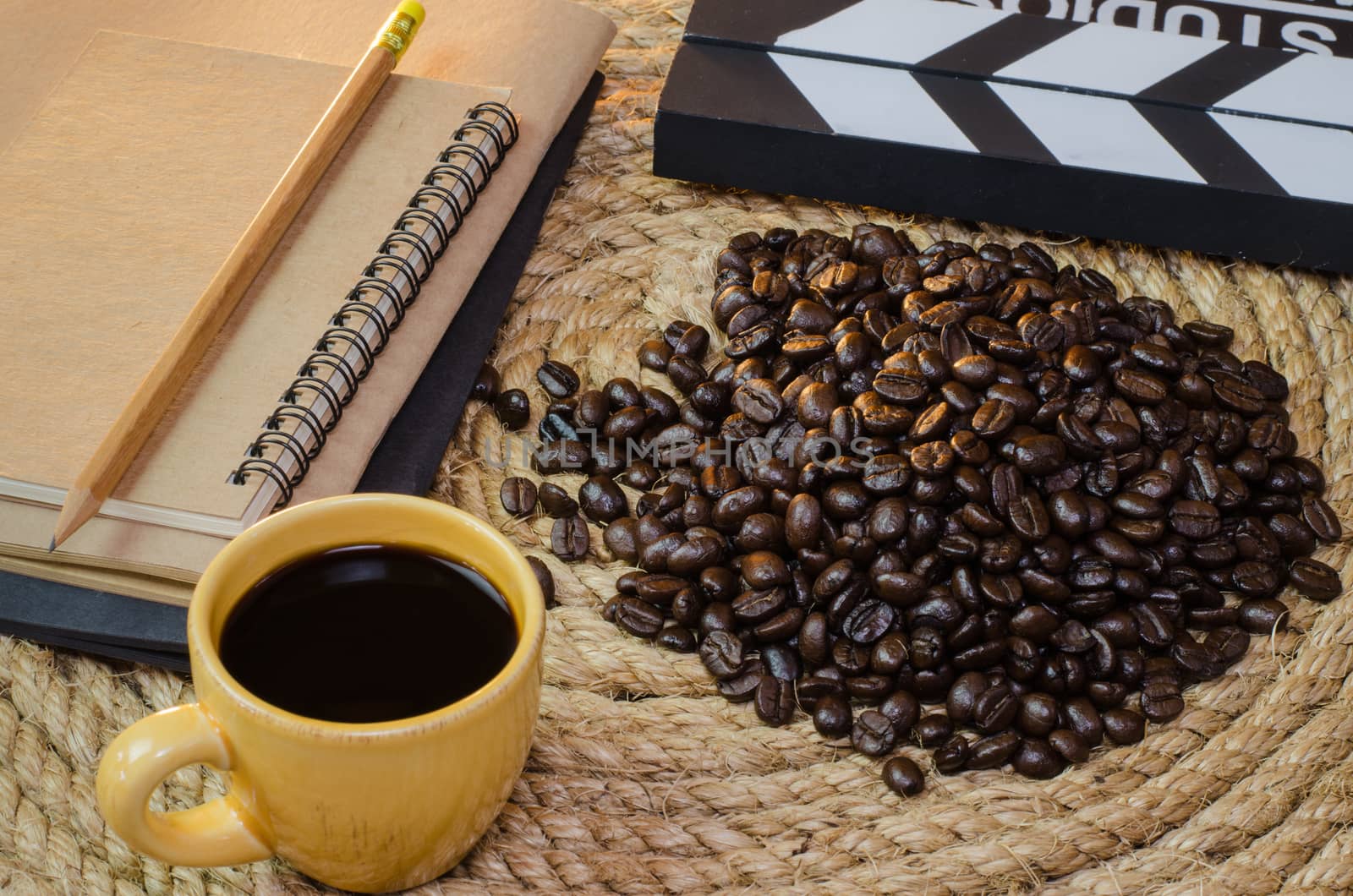 Cup of coffee with  notebook slate on a jute rope.