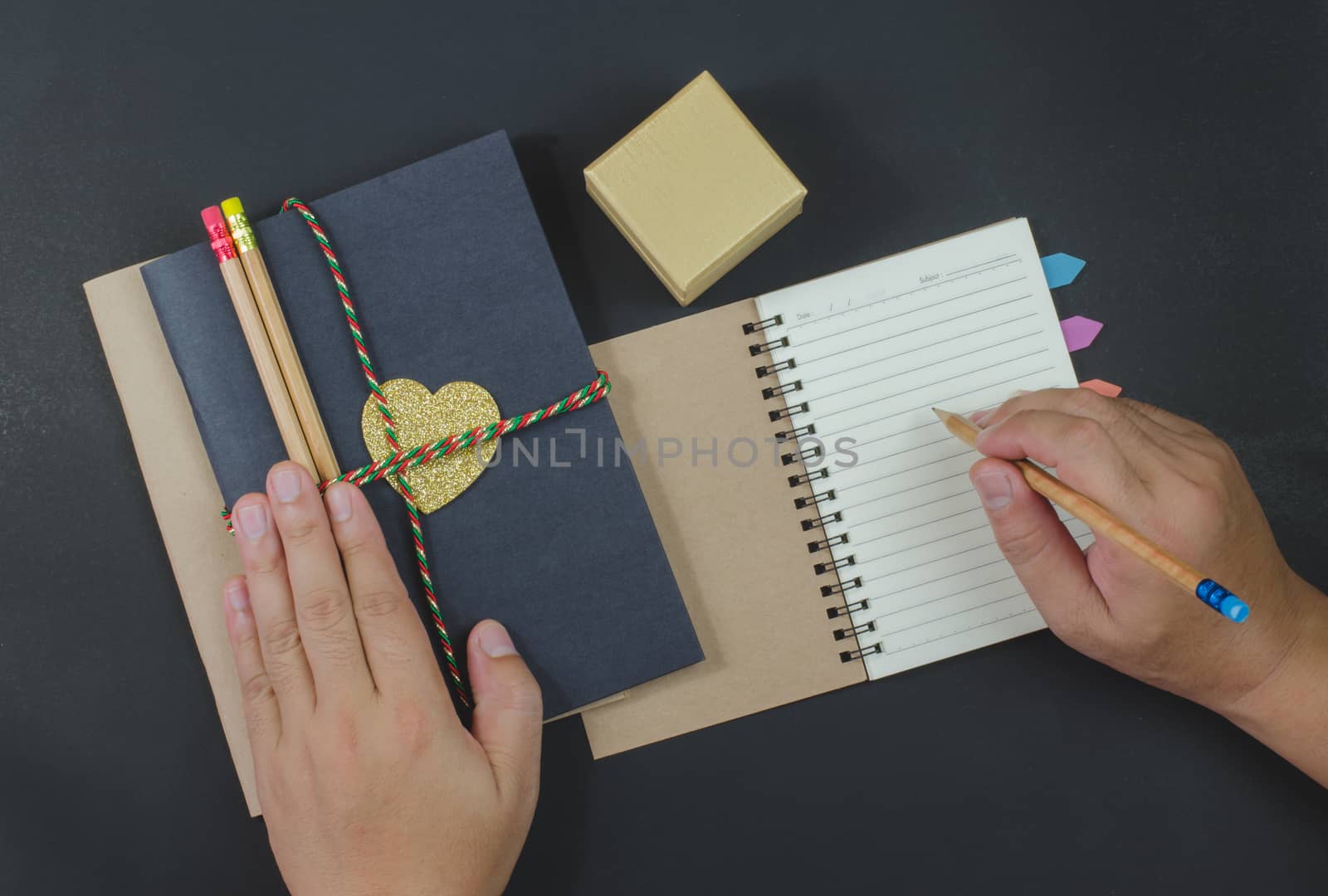 write paper notebook pencils on black background