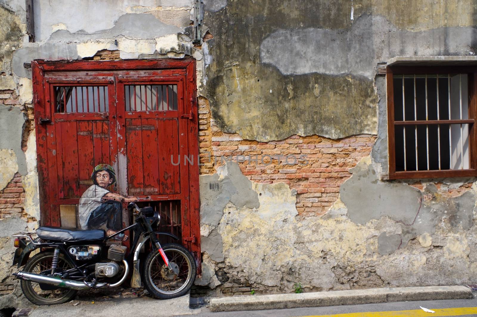 PENANG, MALAYSIA - April 18, 2016: General view of a mural 'Boy on a Bike' painted by Ernest Zacharevic. The mural is one of the 9 murals paintings in early 2012. by evolutionnow