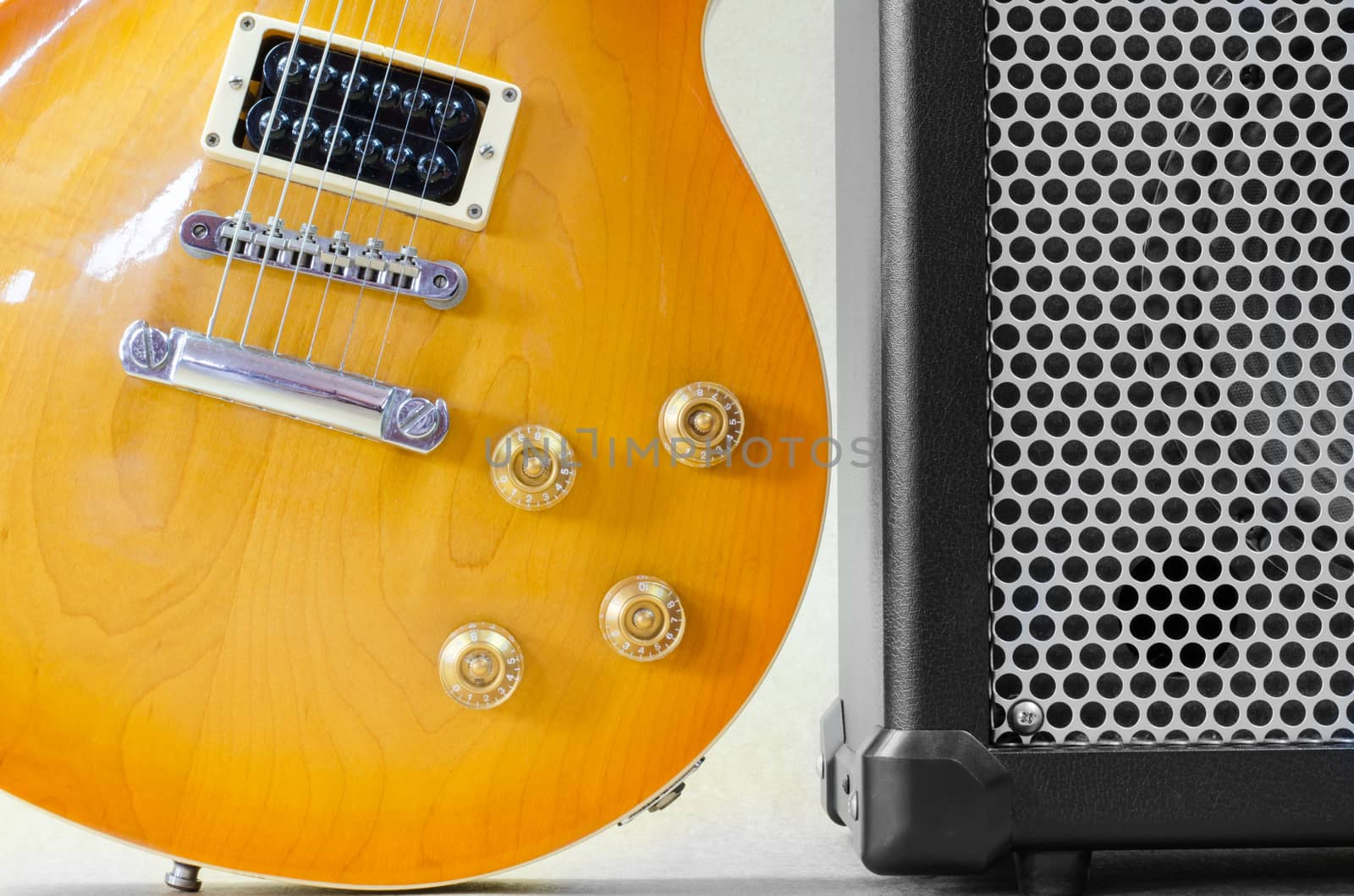 Electric guitar and amplifier isolated on a  light brown