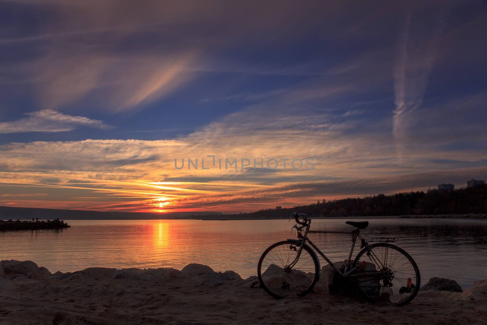 A picture of the sunset at the coast with bicycle