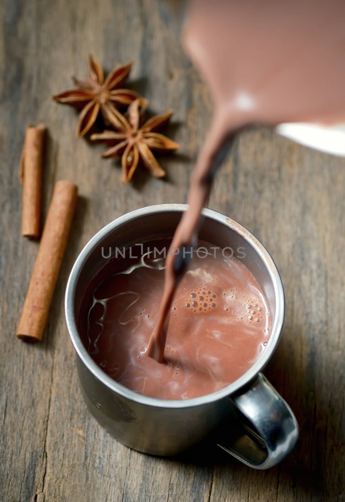 Hot chocolate with cinnamon stick on wooden table