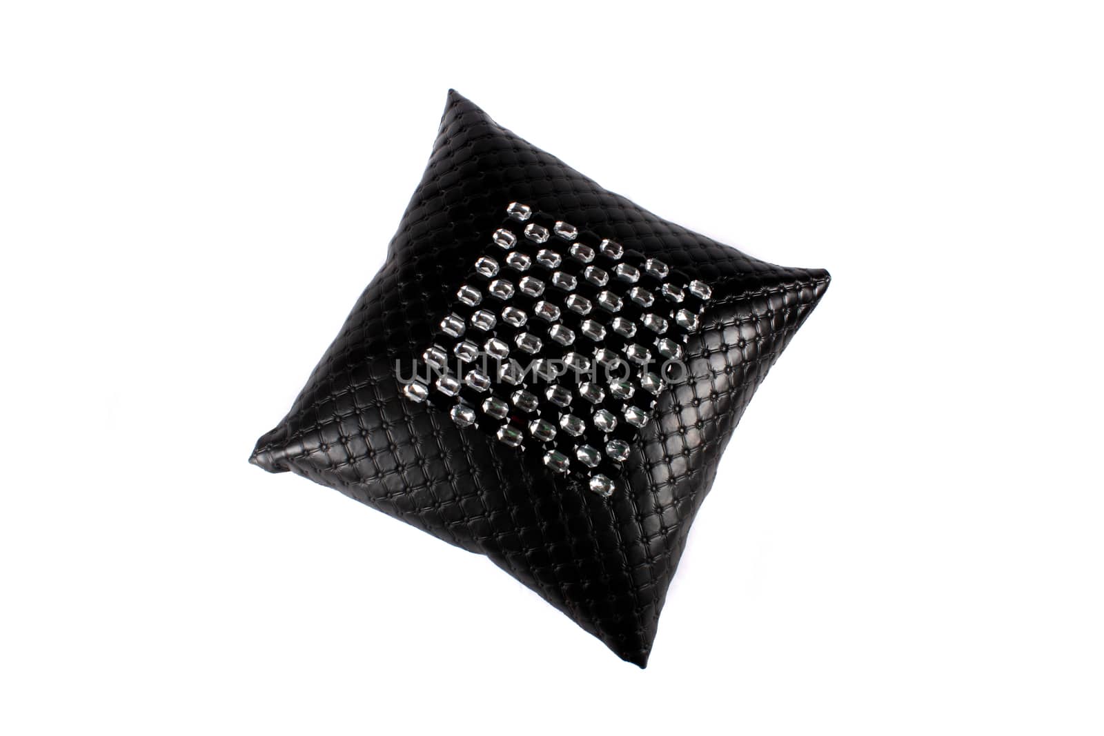 A luxurious black pillow made of leather and designed with glass beads, on white studio background