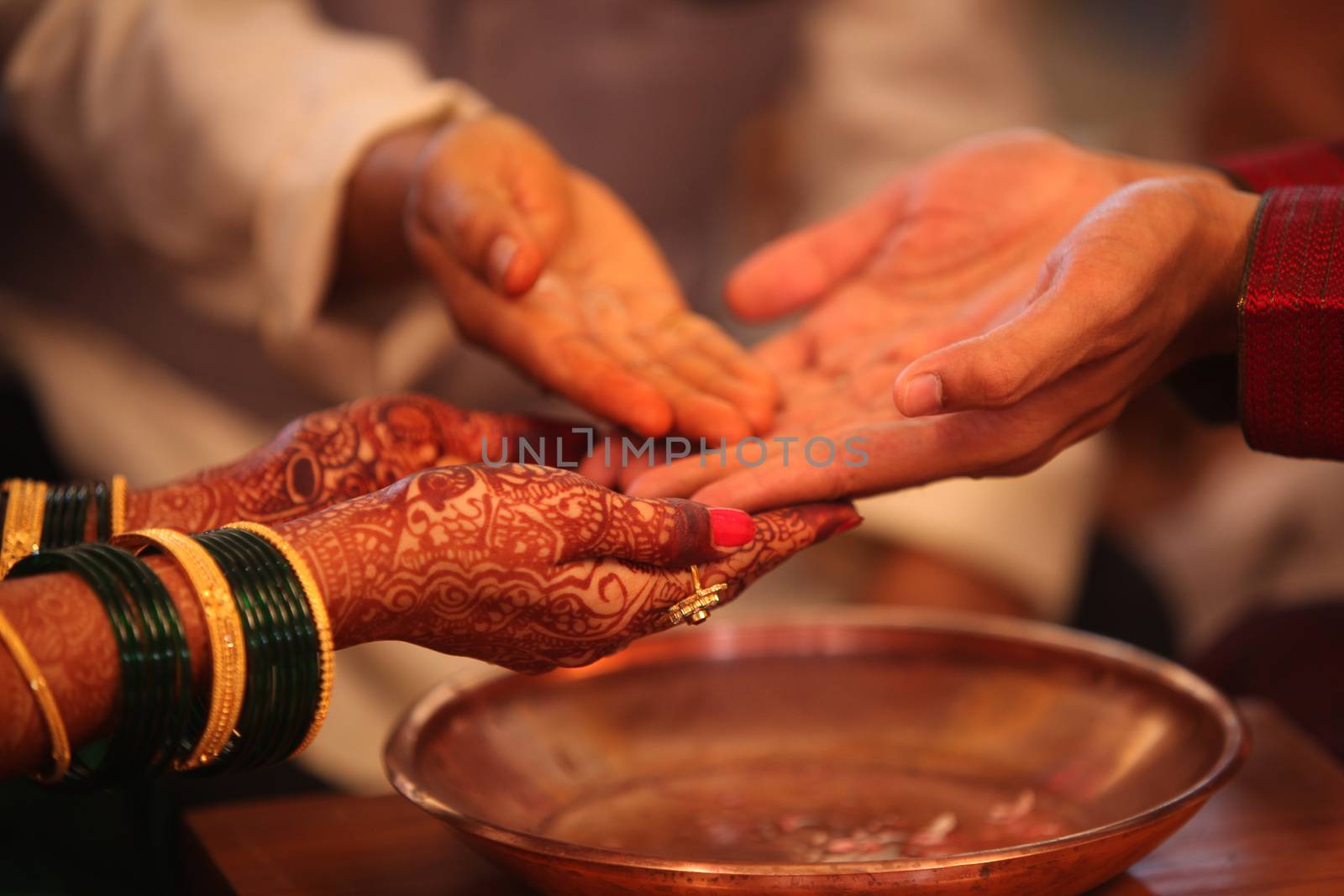 The hands of the bride and groom in a traditional Hindu wedding ritual