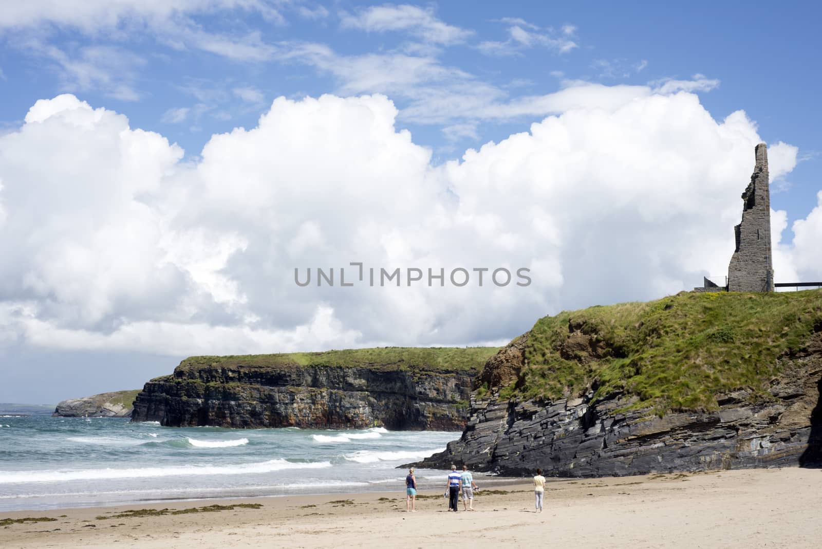 tourists walking the beach cliffs and castle on ballybunion beach county kerry ireland