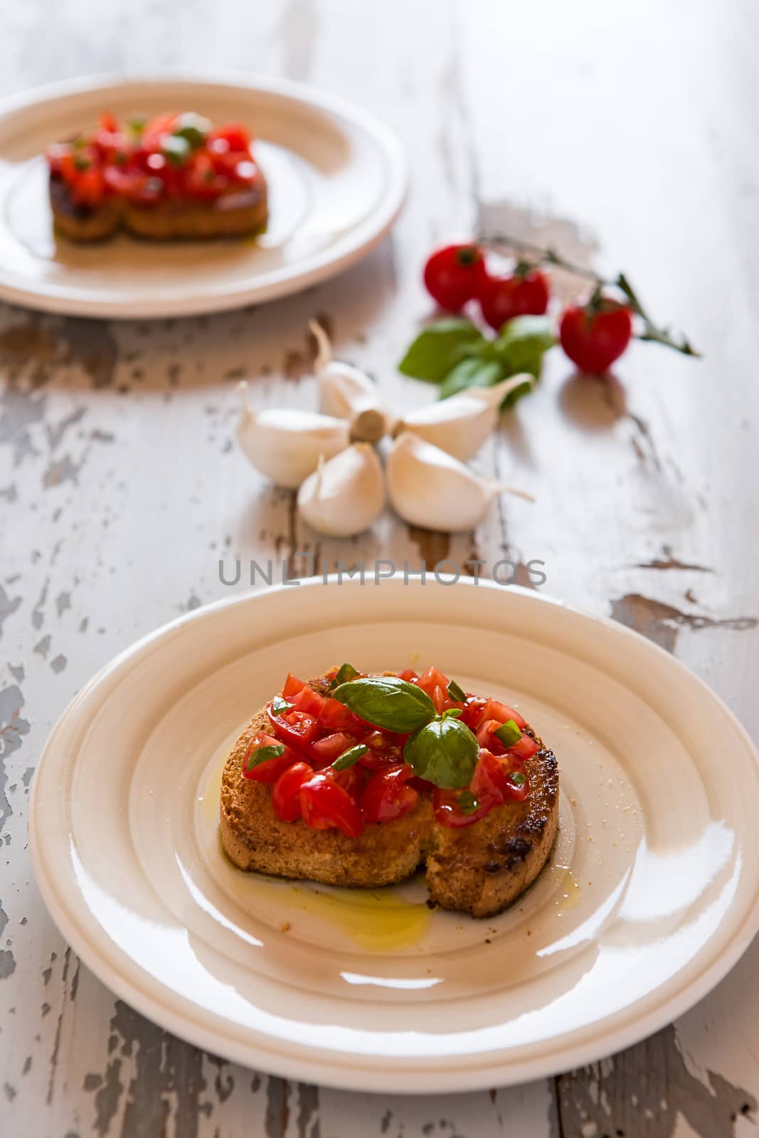 Italian bruschetta with tomato and basil over an old table