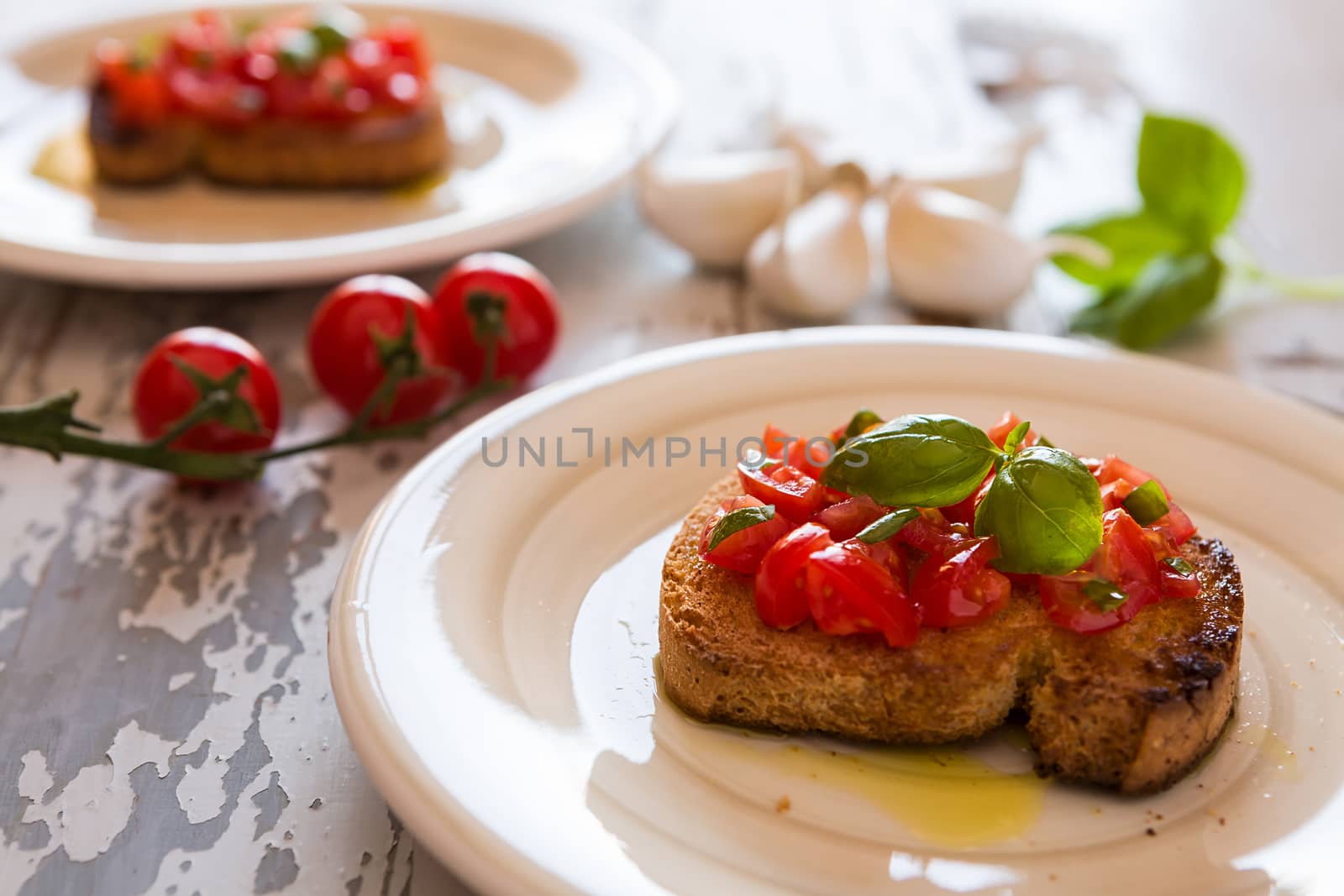 Closeup of Italian bruschetta with tomato and basil over an old table
