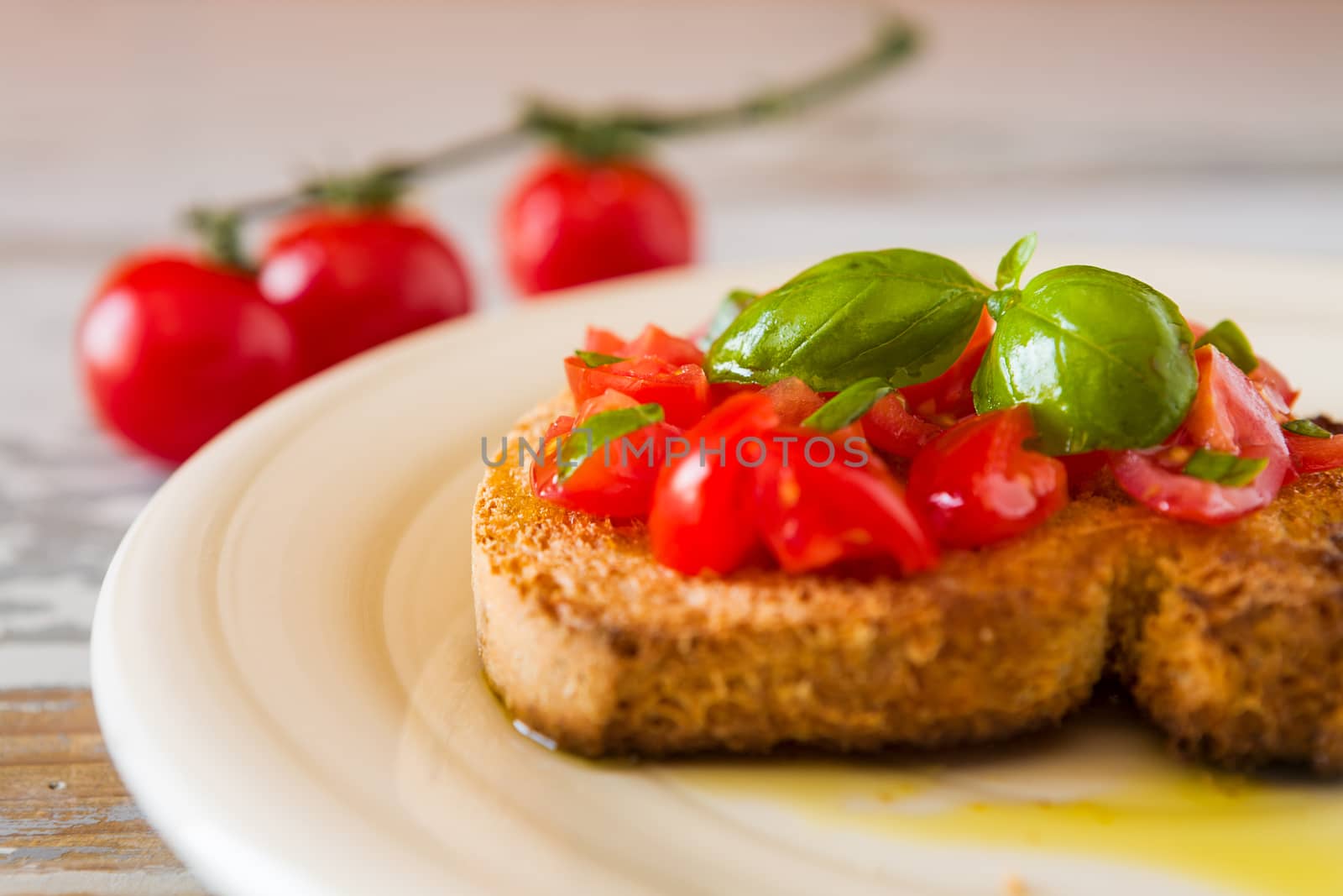 Closeup of bruschetta with tomato and basil over an old table