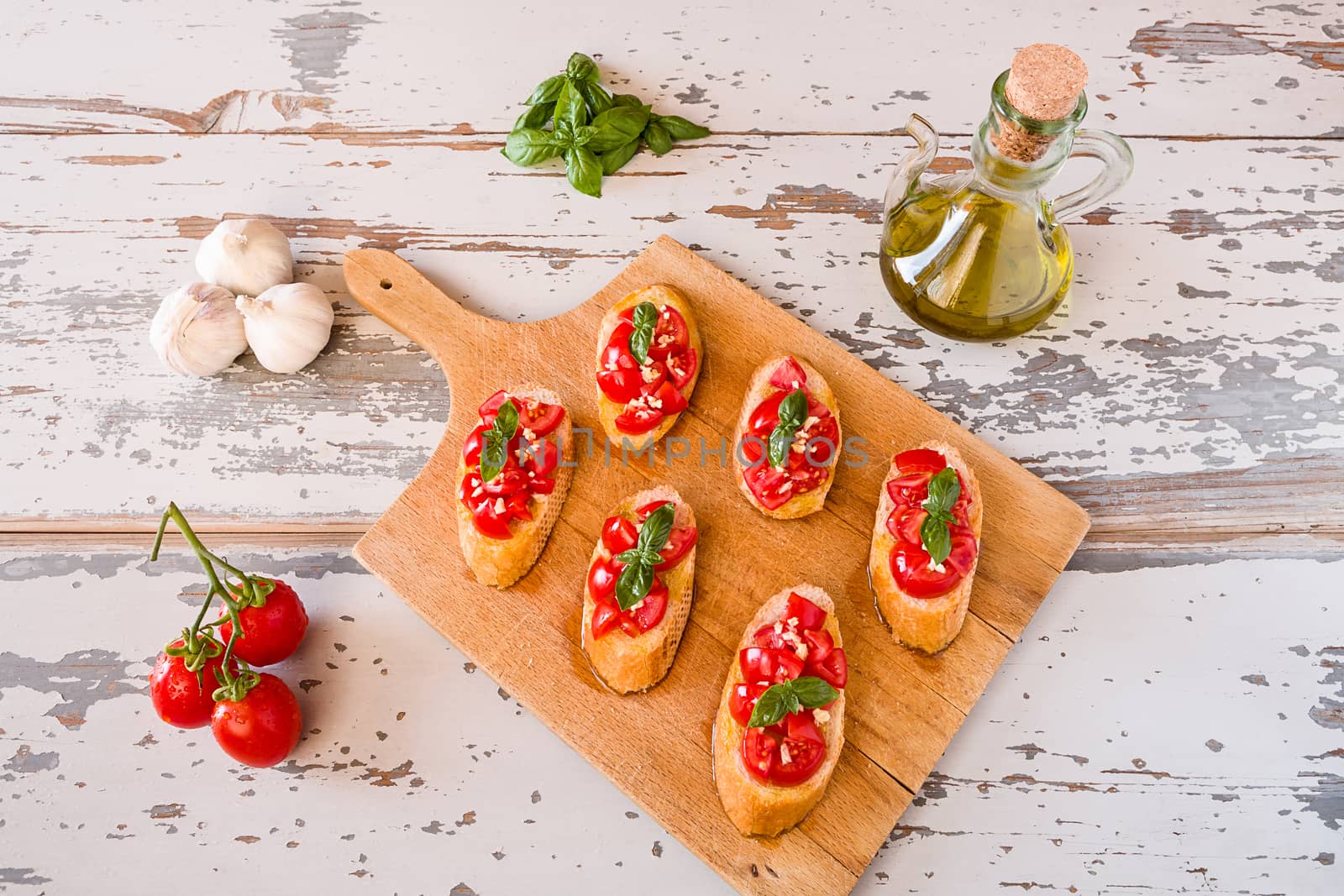Italian bruschetta with tomato, basil and garlic seen from above on a chopping board