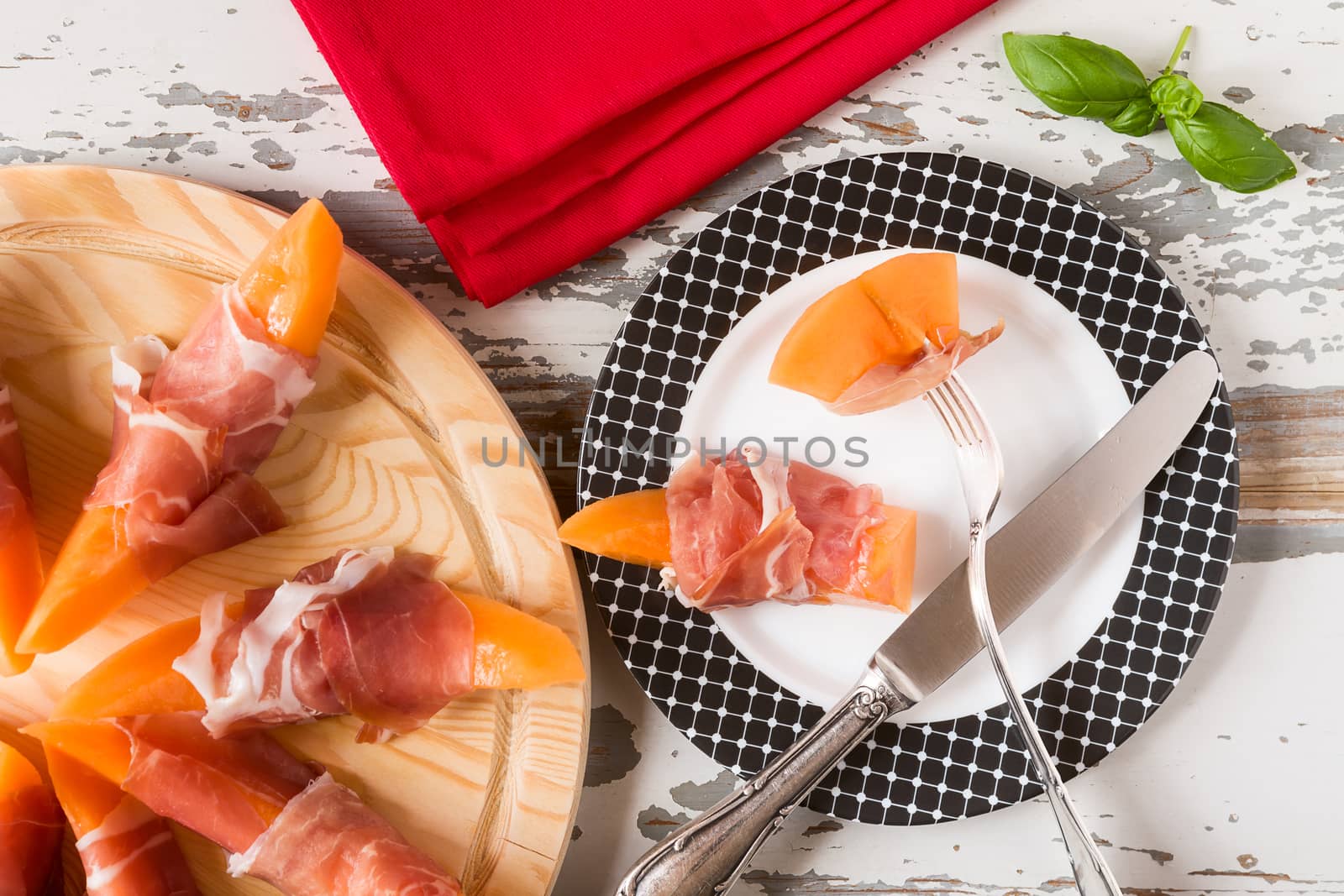 Italian prosciutto and melon on a plate seen from above