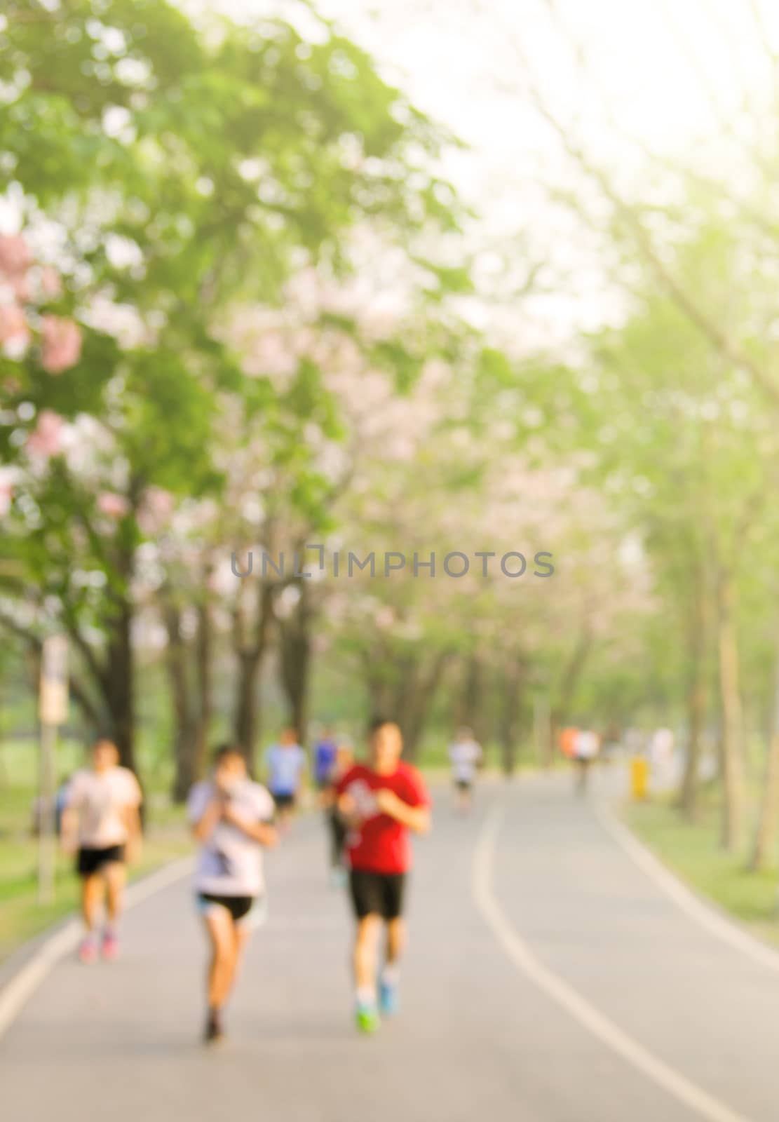 Blurred background of park with running people