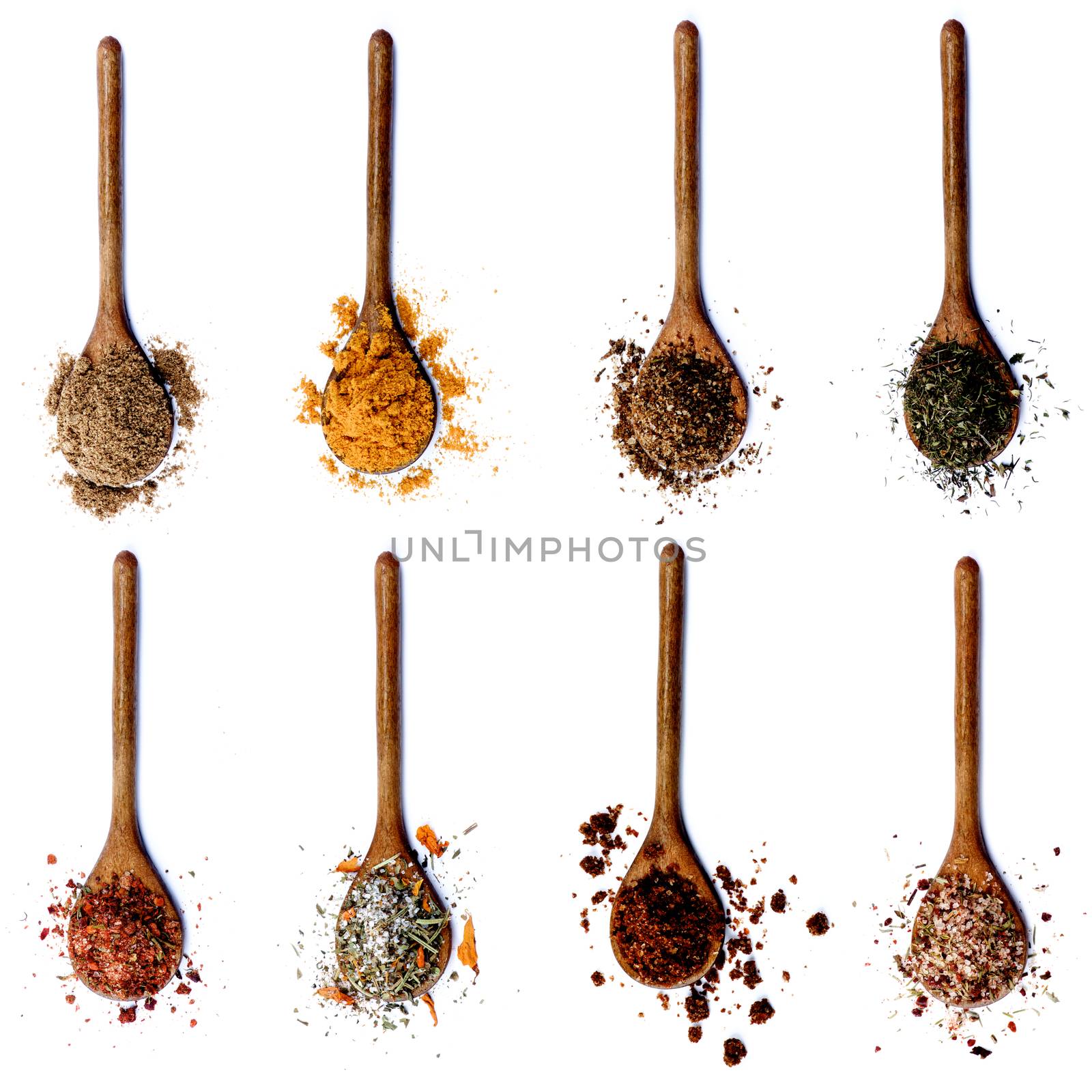 Collection of Various Spices in Wooden Spoons: Coriander, Curry Powder, Salt with Herbs, Thyme, Salt with Cayenne Pepper, Salt with Petals, Dried Paprika and Salt with Chili isolated on White background