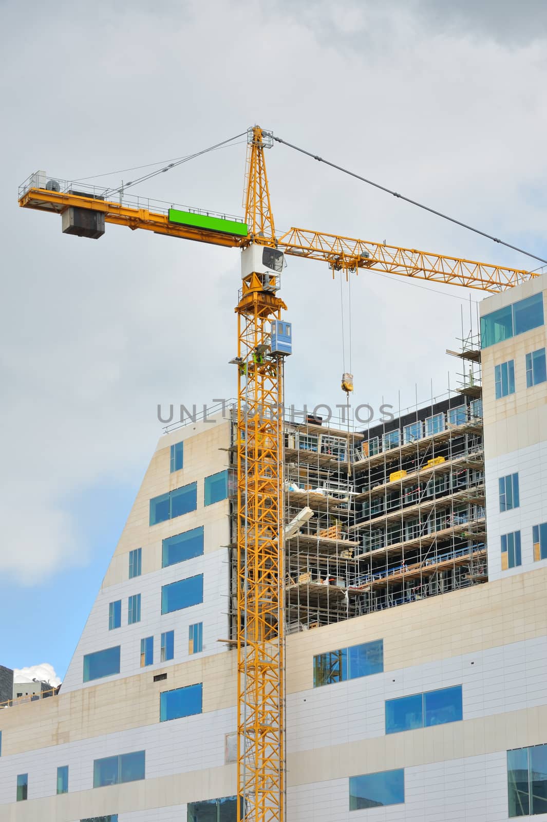 Working crane on a modern office building under construction 