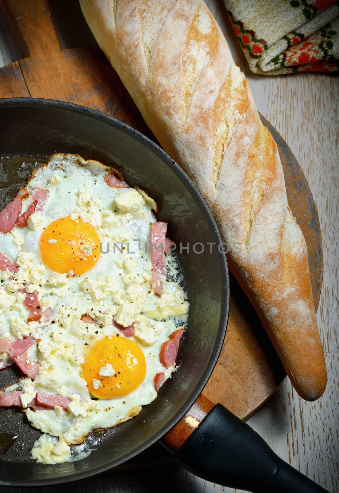 Fried eggs in a frying pan with bread for breakfast