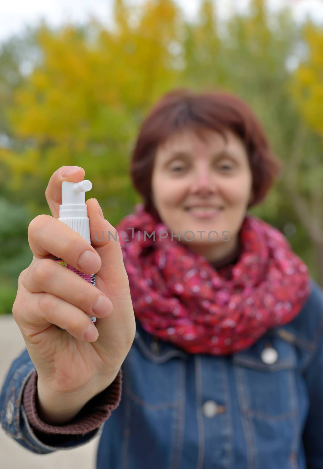 Woman using throat spray in cold season