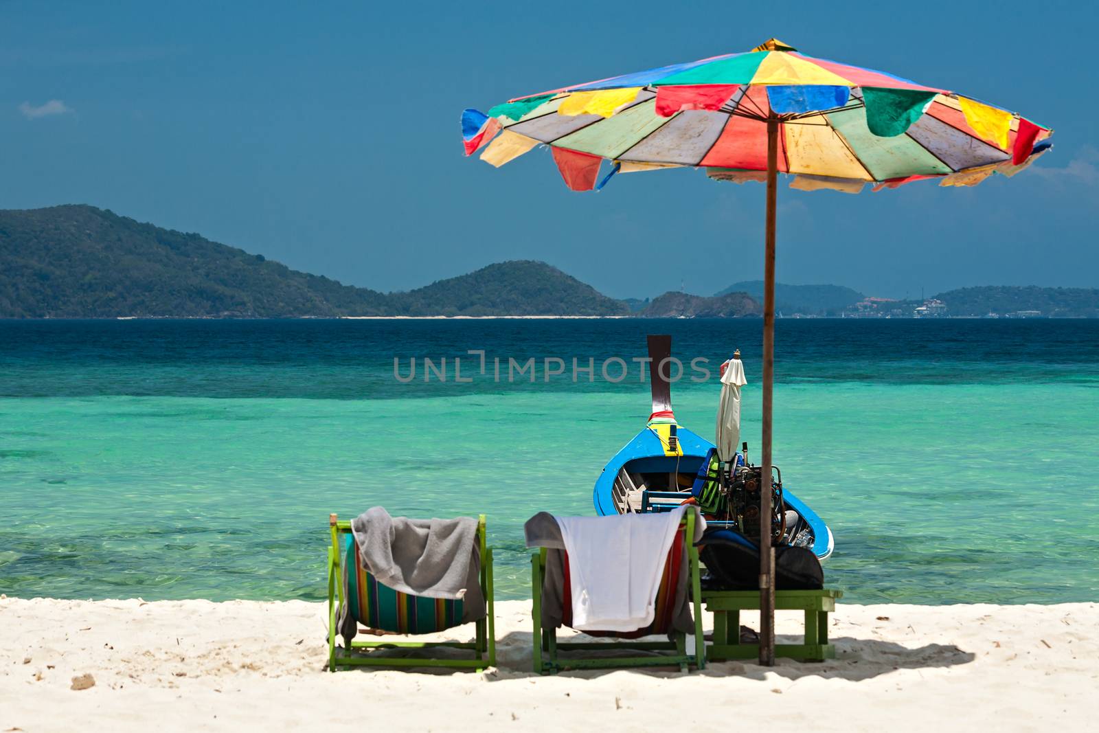Beach umbrella chairs and boat in Coral island, Thailand by LuigiMorbidelli
