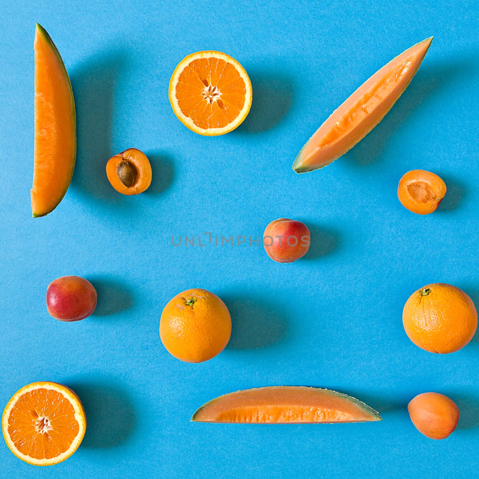 Fresh orange toned fruits over a blue background