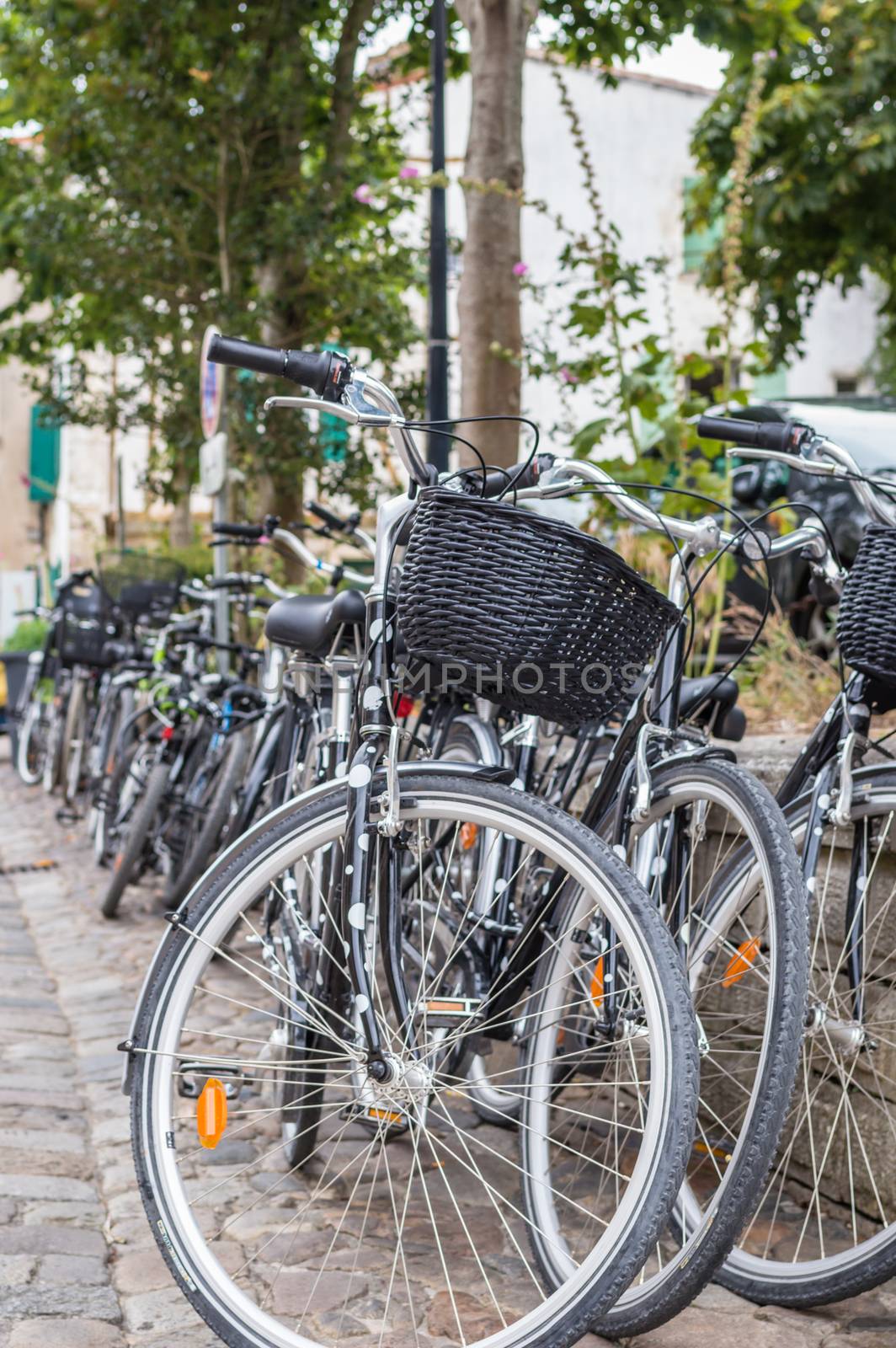 City bicycle with basket in front parked in a paved street