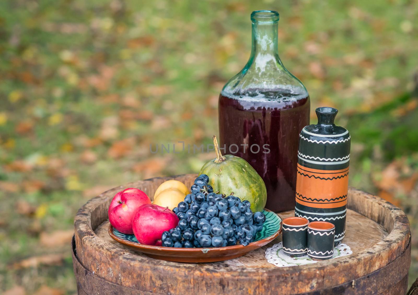 still life with oak barrel of fruit and red wine in the garden autumn
