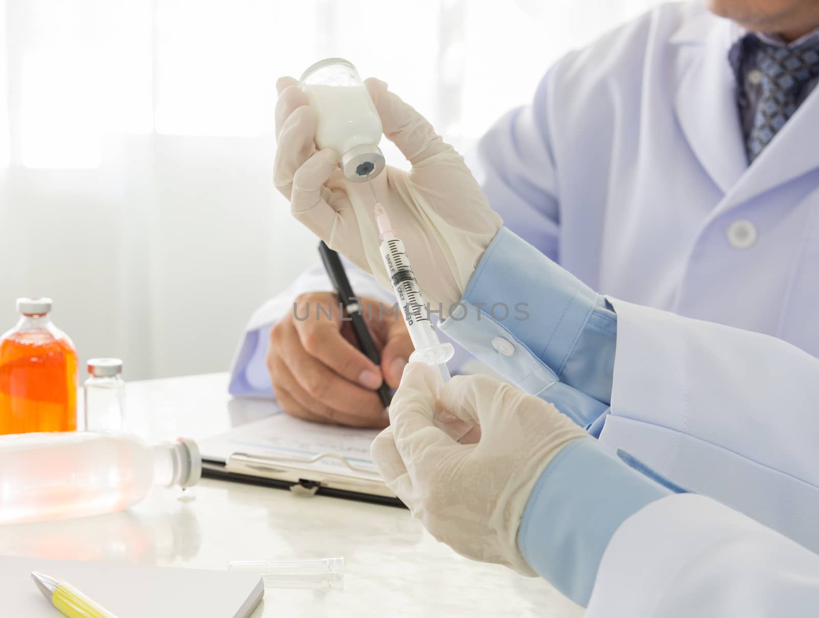 Doctor filling of a syringe with medicine from vial in hospital. healthcare and medical concept