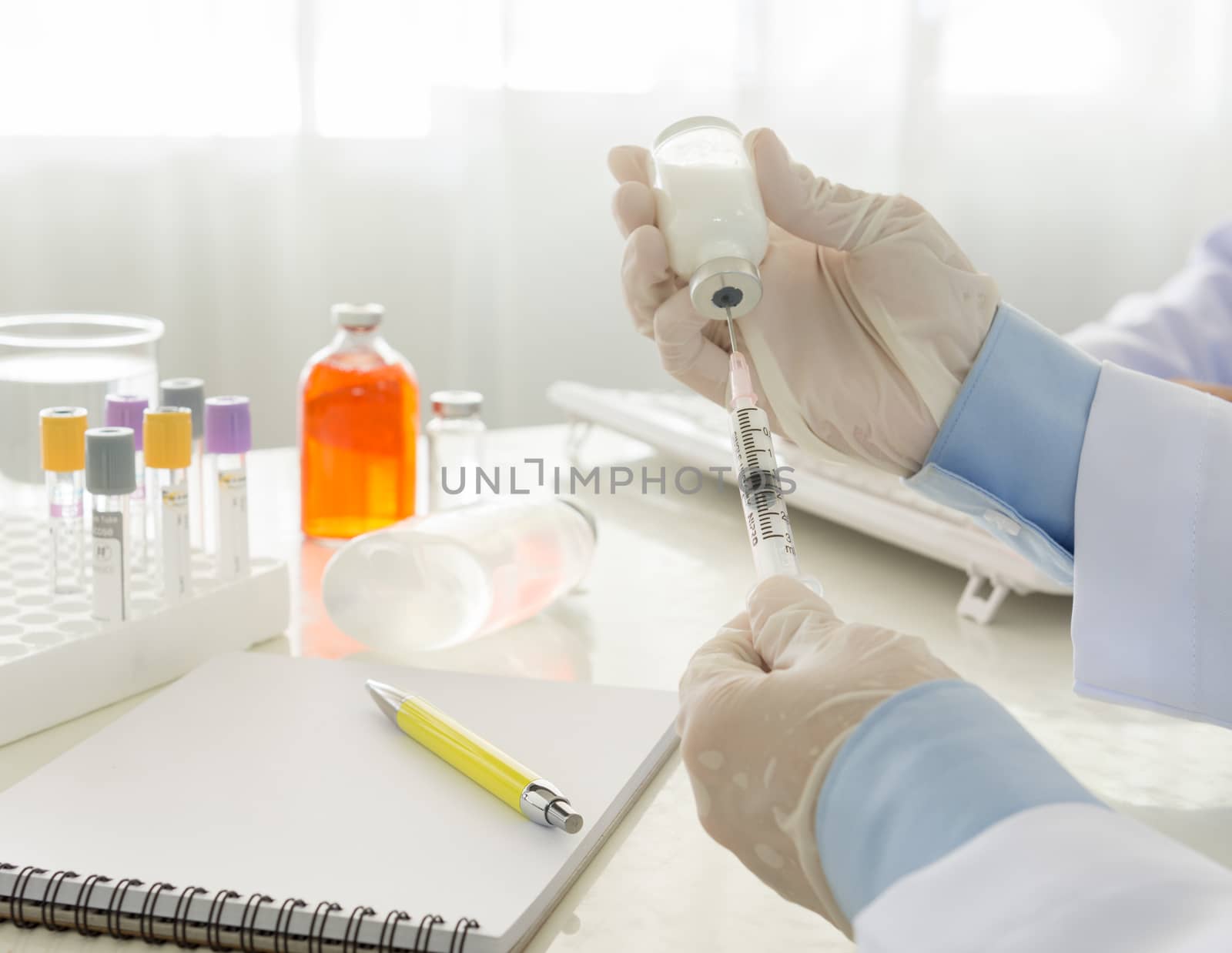 Doctor filling of a syringe with medicine from vial in hospital. healthcare and medical concept