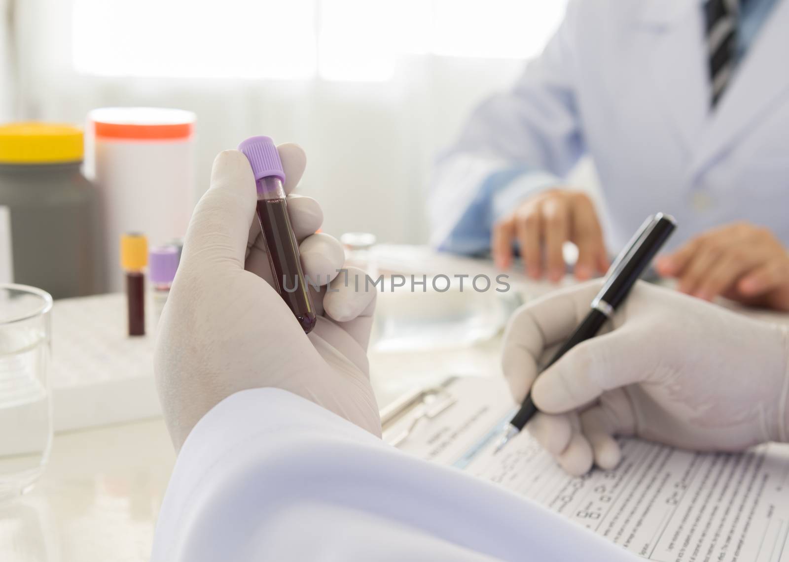 Doctor holding a bottle of blood sample in lab. science and medical concept