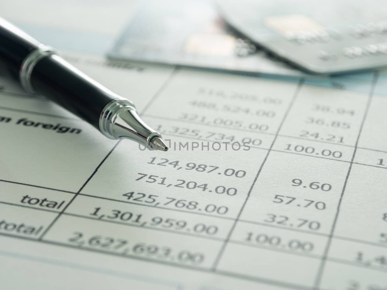 pen and creditcard on  report. selective focus.