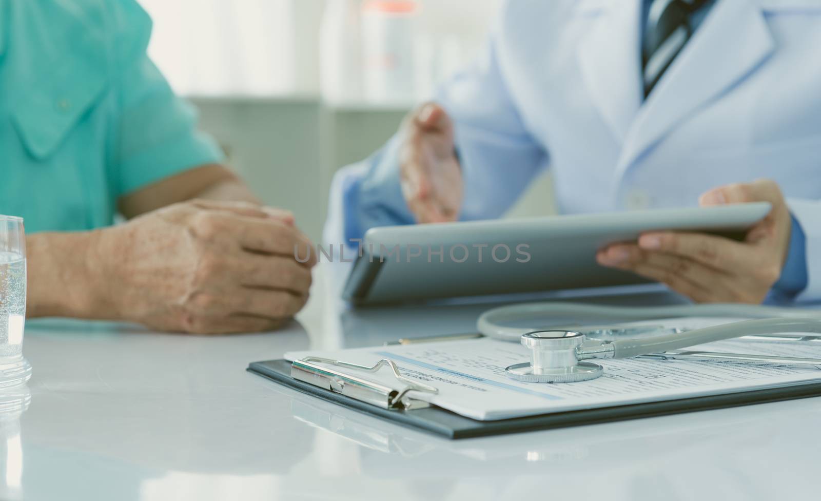 close up stethoscope on application form with doctor and patients in background.