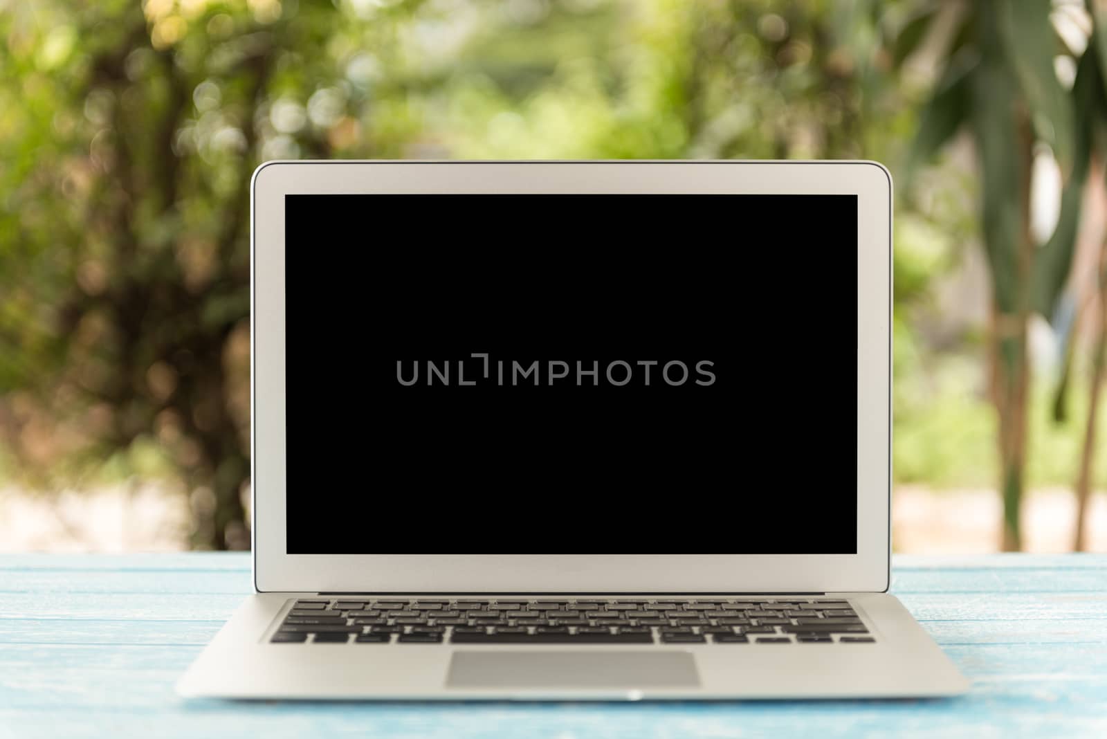 Laptop computer on table in nature background. mock up free space for your design.