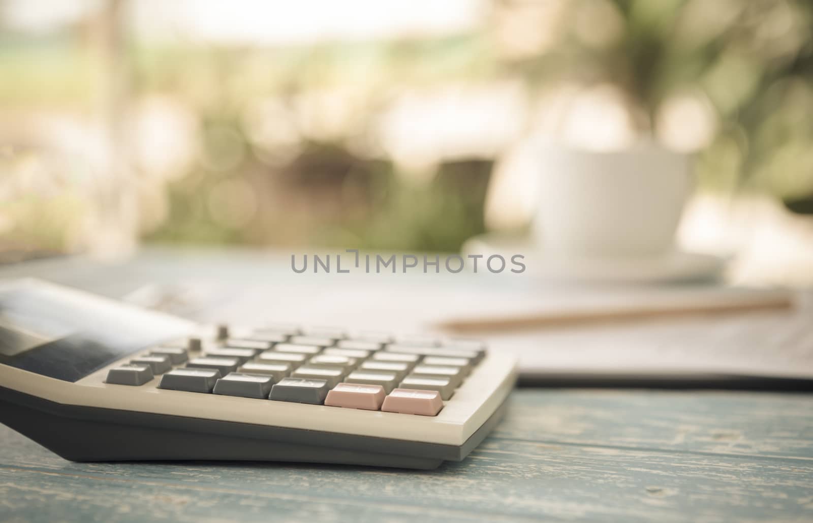 Calculator on the table in the backyard. finance,account,economy at home concepts. vintage style.