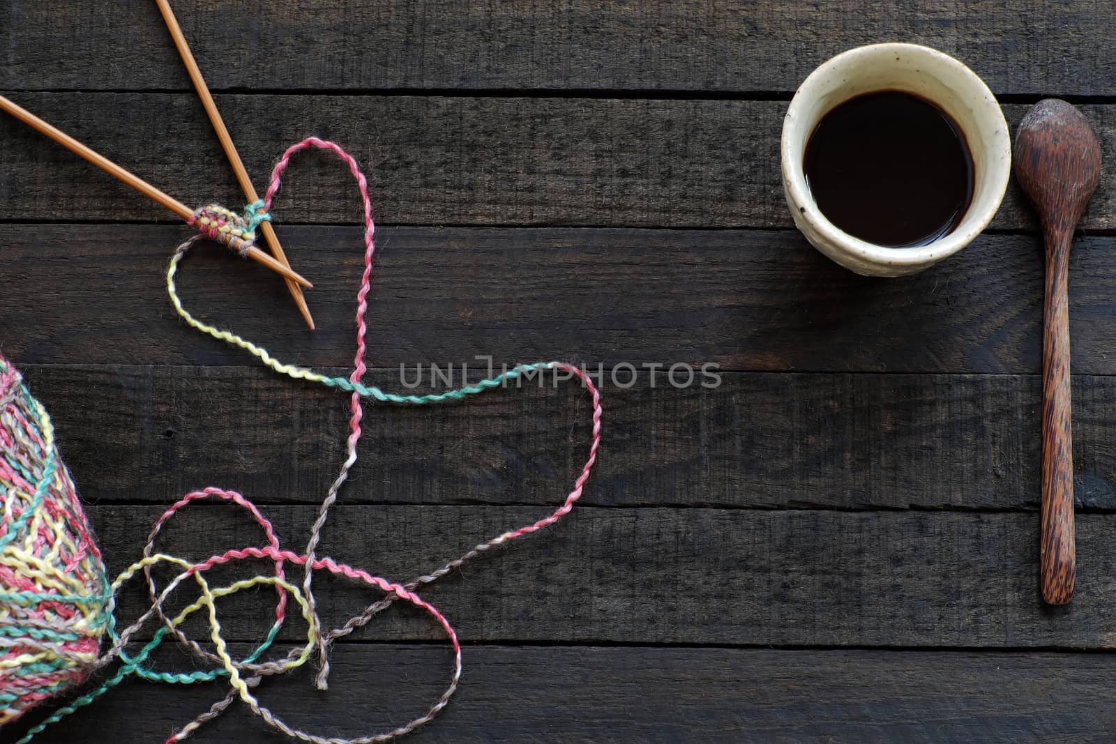 Knitted background with knitting needle, yarn and coffee cup, knit is hobby, leisure activities of many people in free time, also make many handmade product