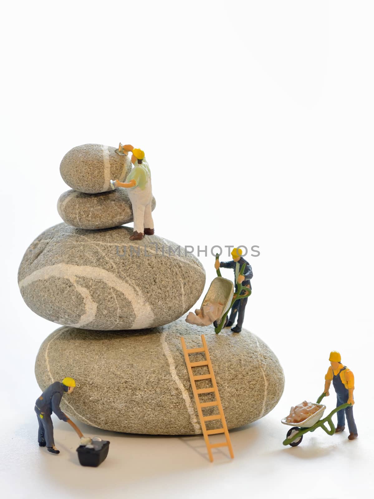 Pebbles stack and figurines of construction workers