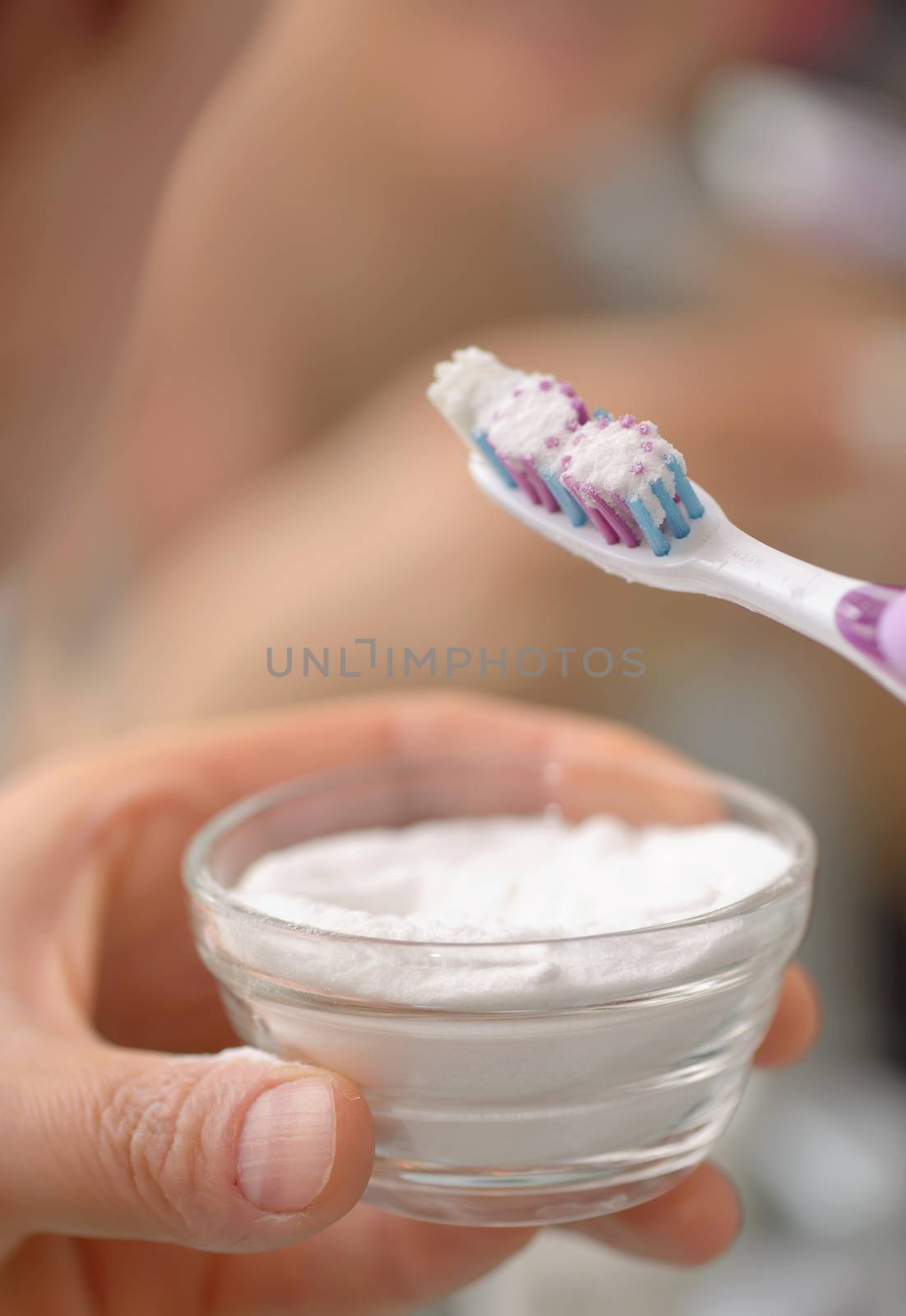 Woman brightening teeth with sodium bicarbonate
