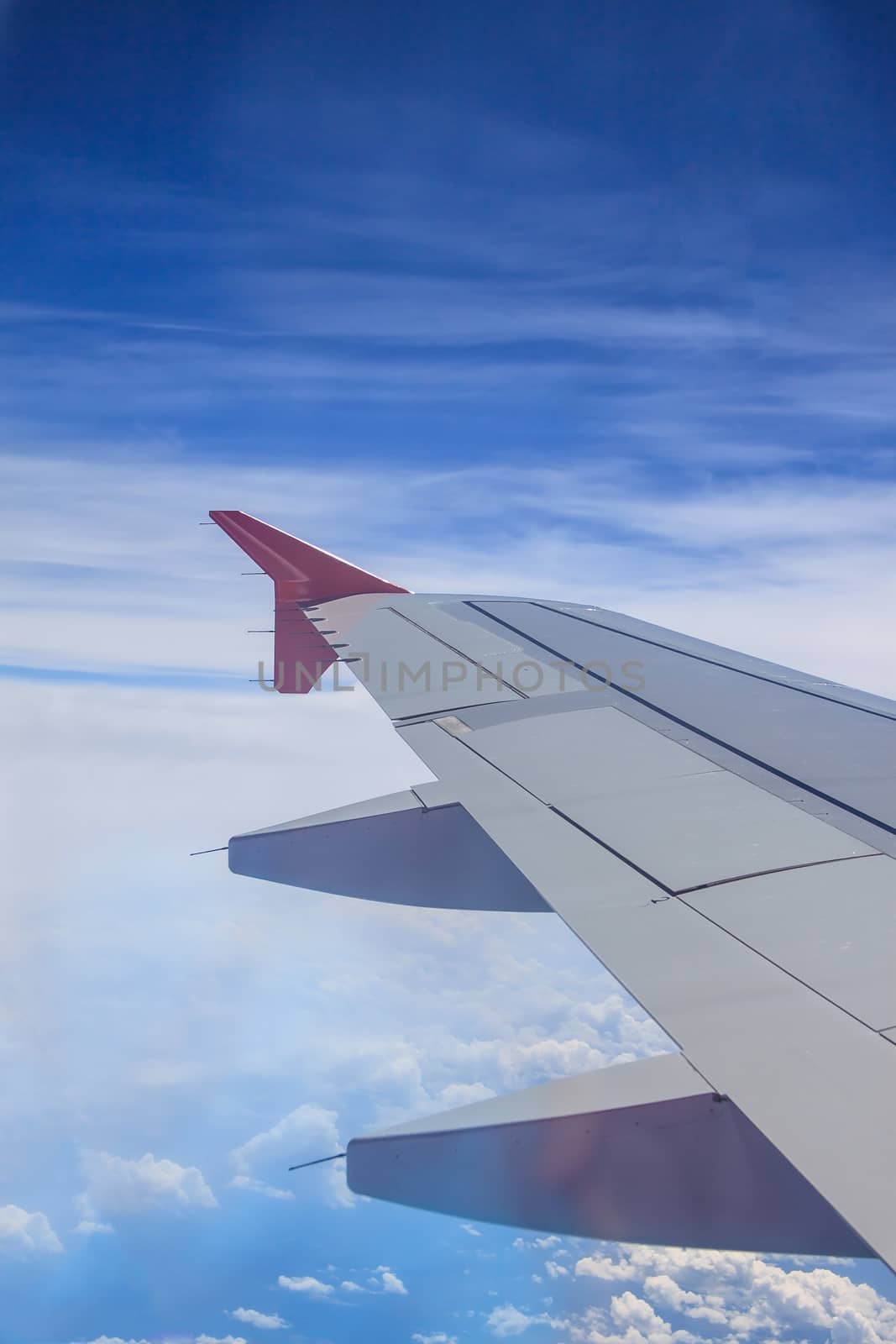 view of jet plane wing with cloud and blue sky by worrayuth