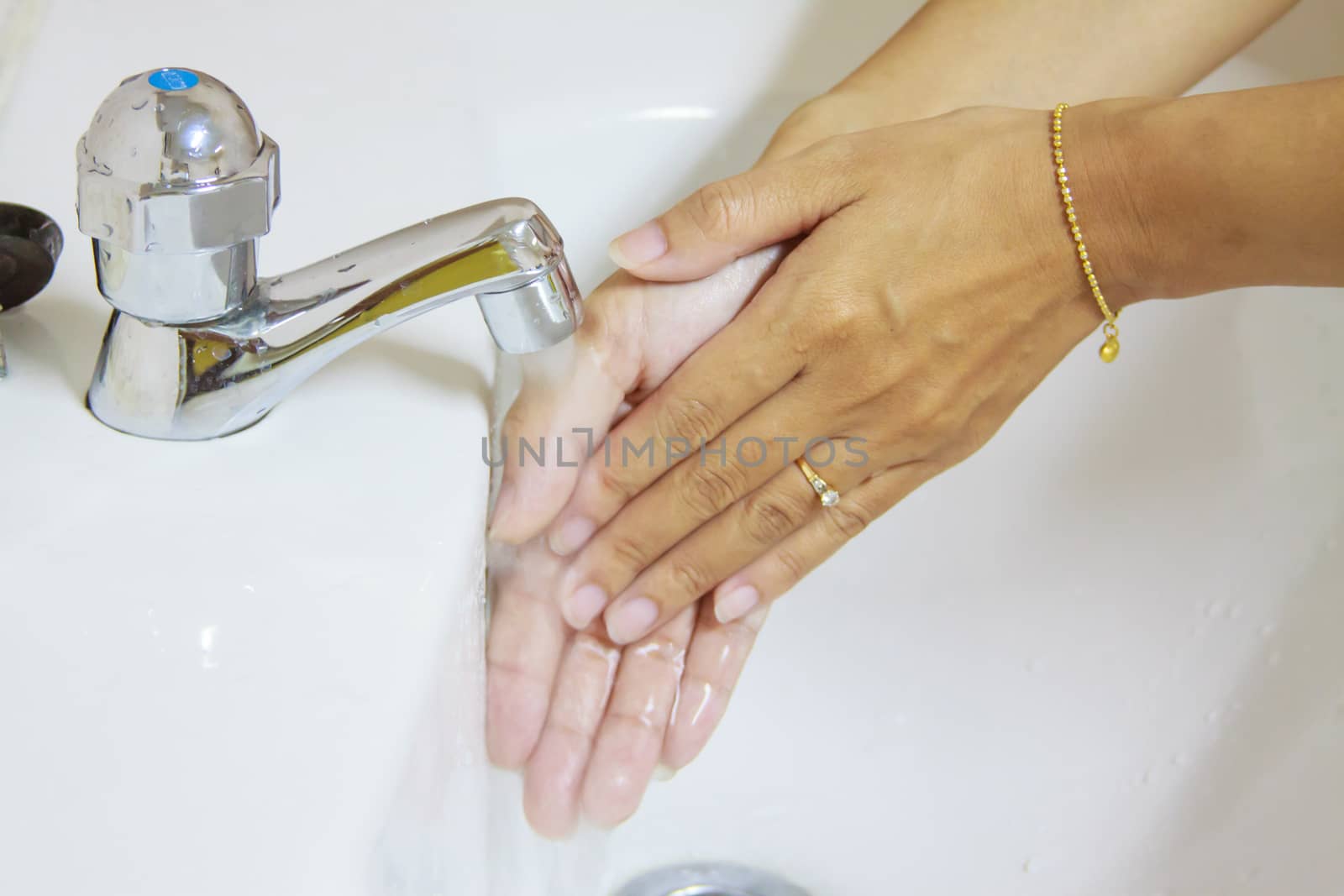 Woman washing hand under running