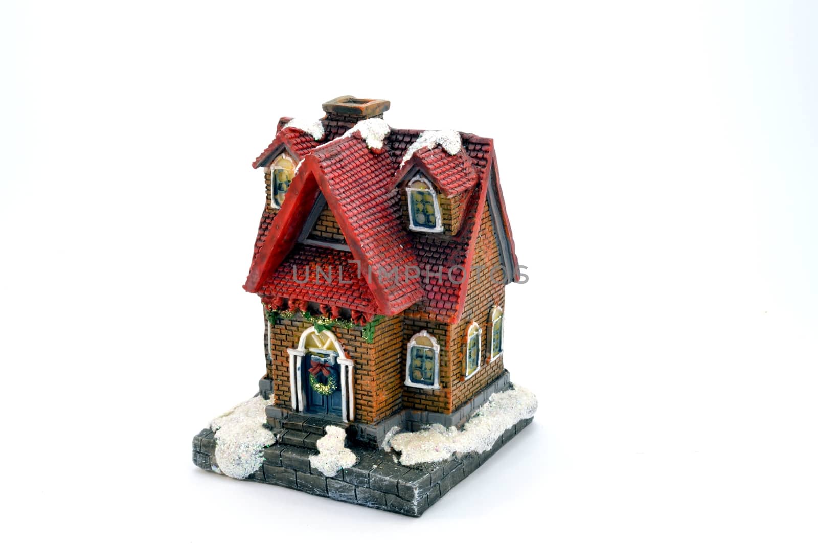 Small plastic house under the snow with a red roof in tiles