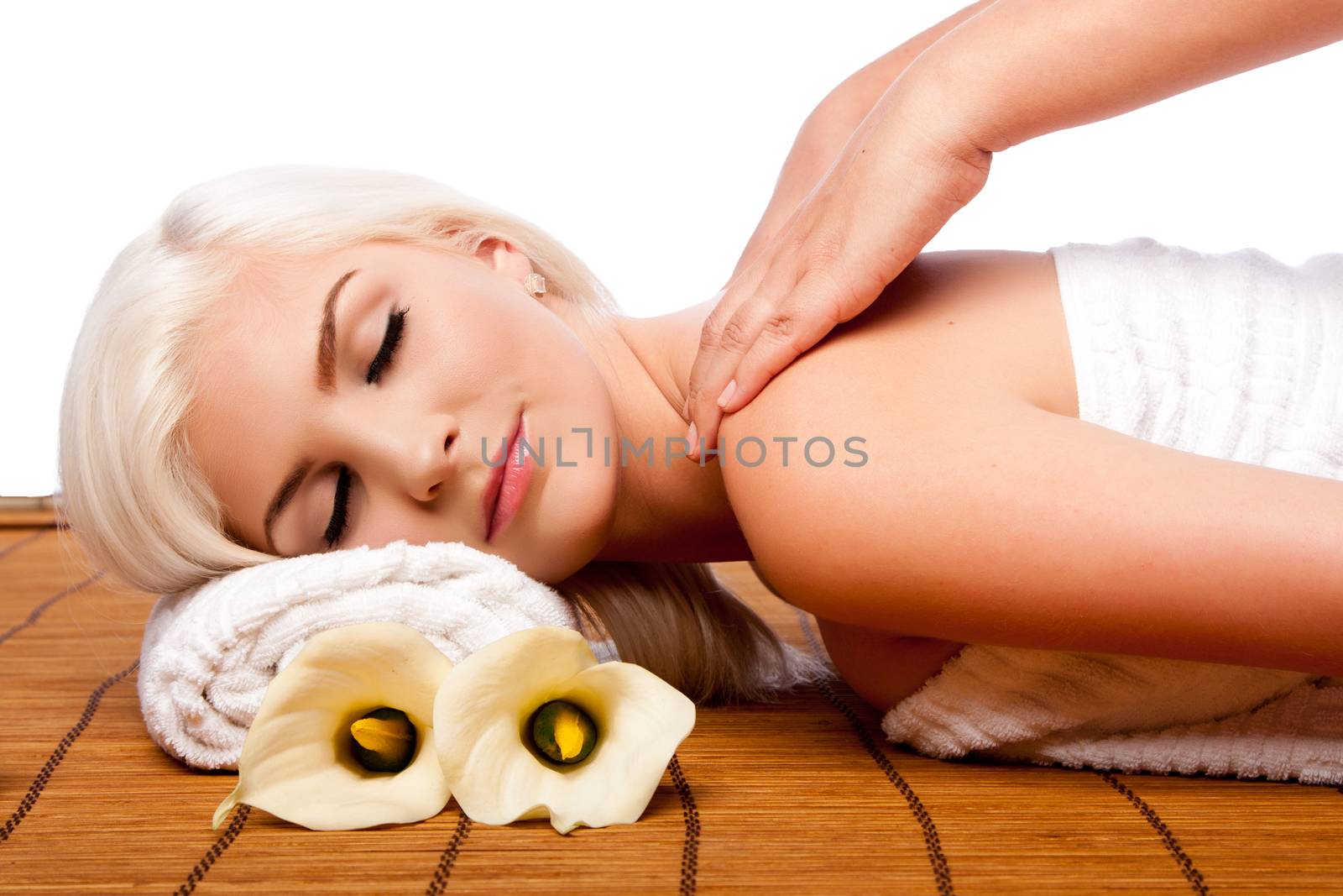 Beautiful young woman relaxing at spa getting therapeutic pampering shoulder massage.