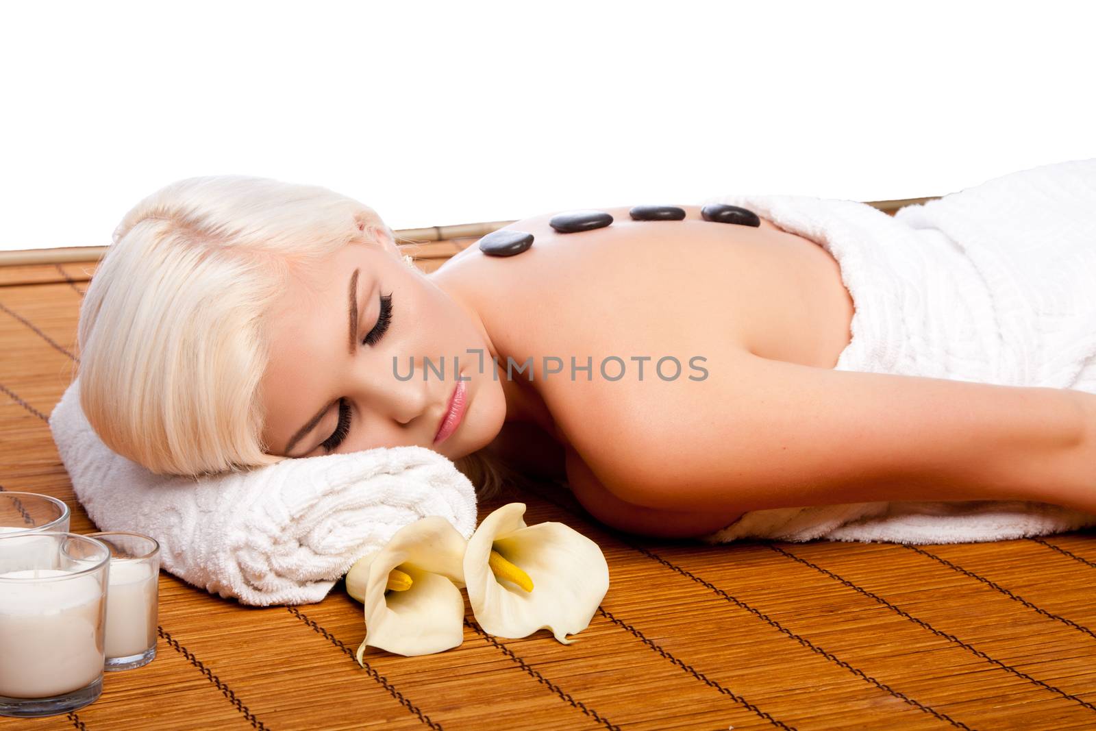 Beautiful young woman relaxing at spa getting therapeutic pampering lastone therapy.