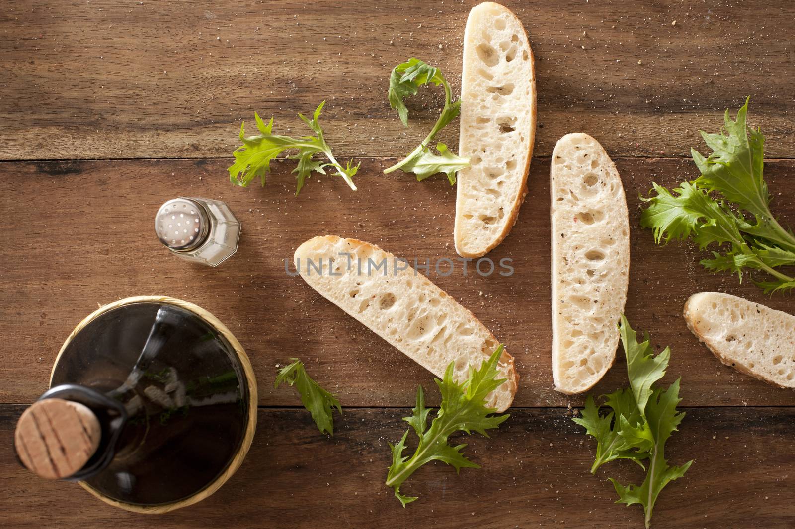 Slices of fresh baguette with rocket leaves by stockarch