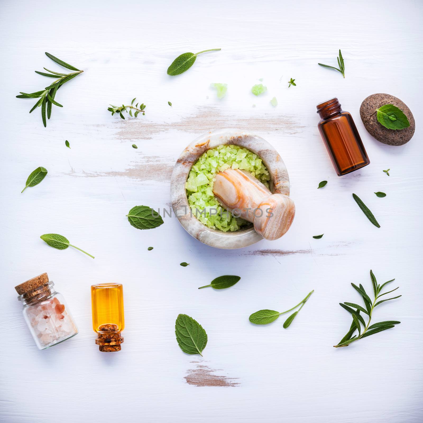 Aromatic sea salt with aromatic herbs . Fresh peppermint ,sage and rosemary. Nature spa ingredients and body scrub. Herbal remedies. Flat lay on white wooden table.