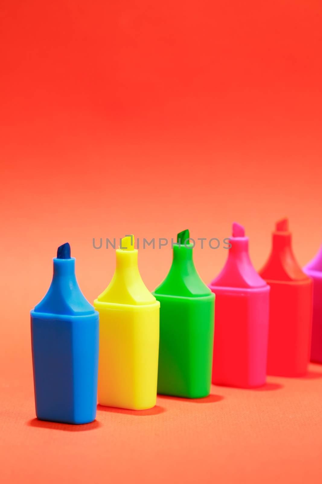 Set of color markers in a row on nice red background