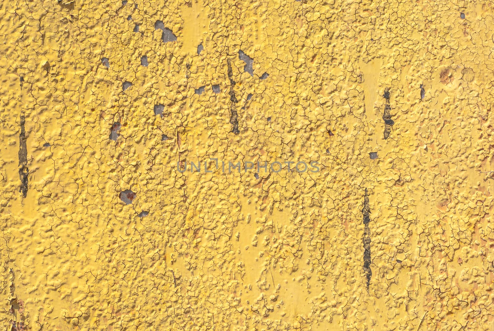 fragment of an iron surface is covered with yellow color paint, which has long been under the influence of different climatic conditions