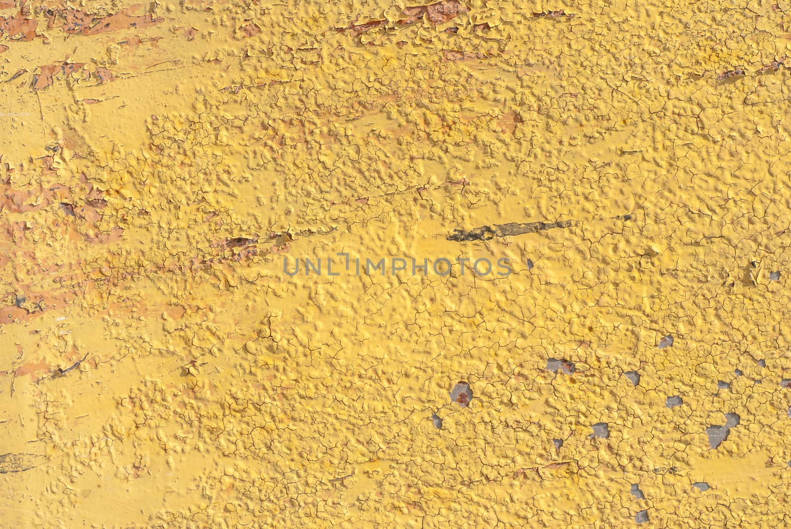 fragment of an iron surface is covered with yellow color paint, which has long been under the influence of different climatic conditions