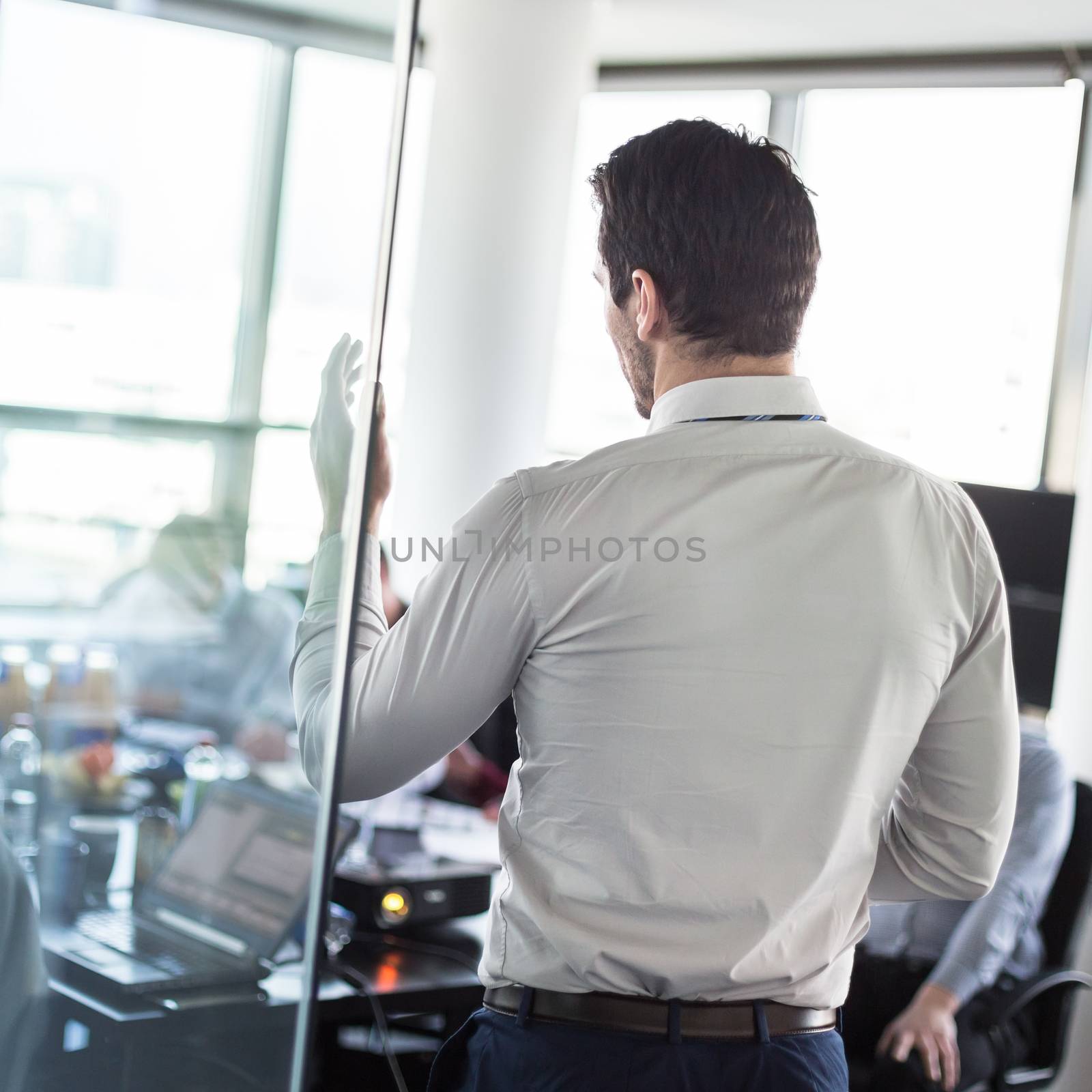 Business man making a presentation at office. Business executive delivering a presentation to his colleagues during meeting or in-house business training, explaining business plans to his employees. 