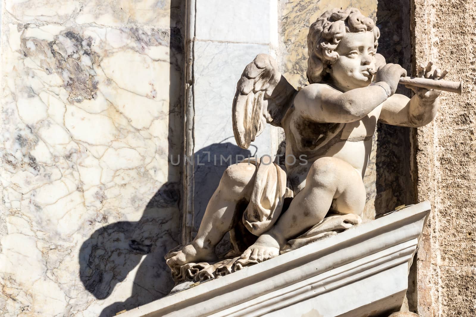 the statue of a cherub with a flute