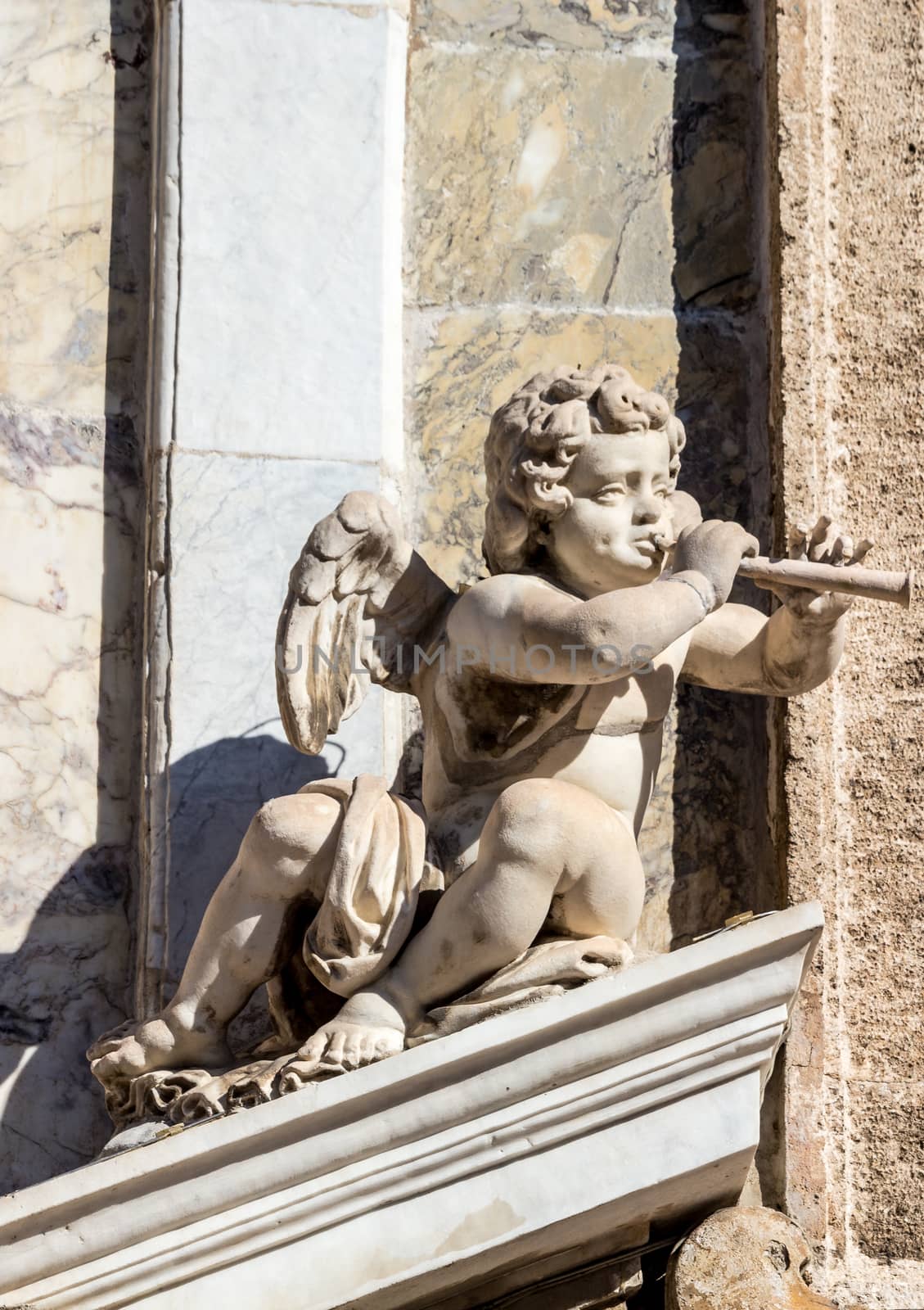 the statue of a cherub with a flute