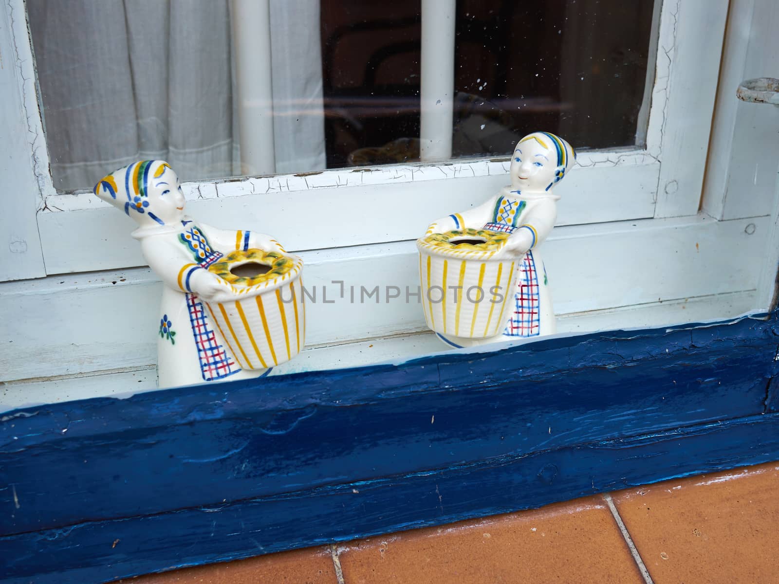 Classical European porcelain figurines in a window by Ronyzmbow