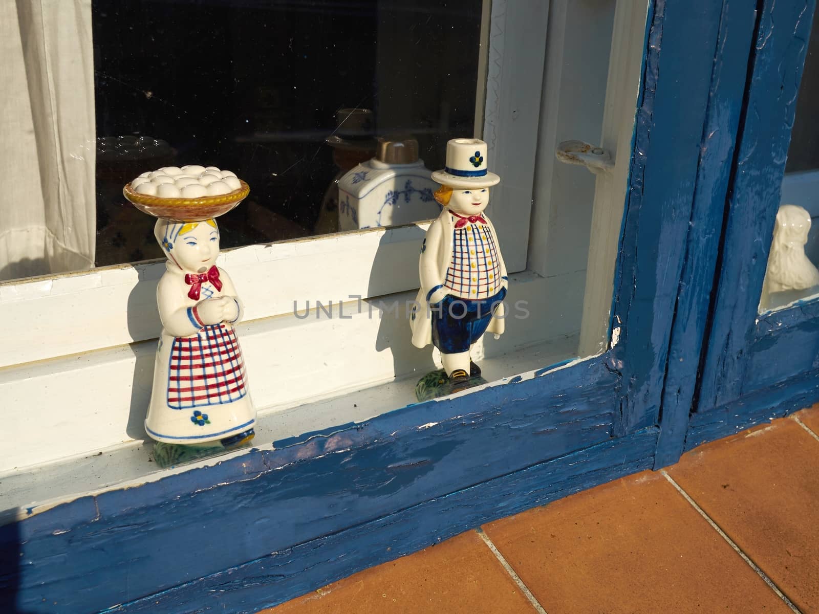 Classical vintage handmade European porcelain figurines in a window of a home