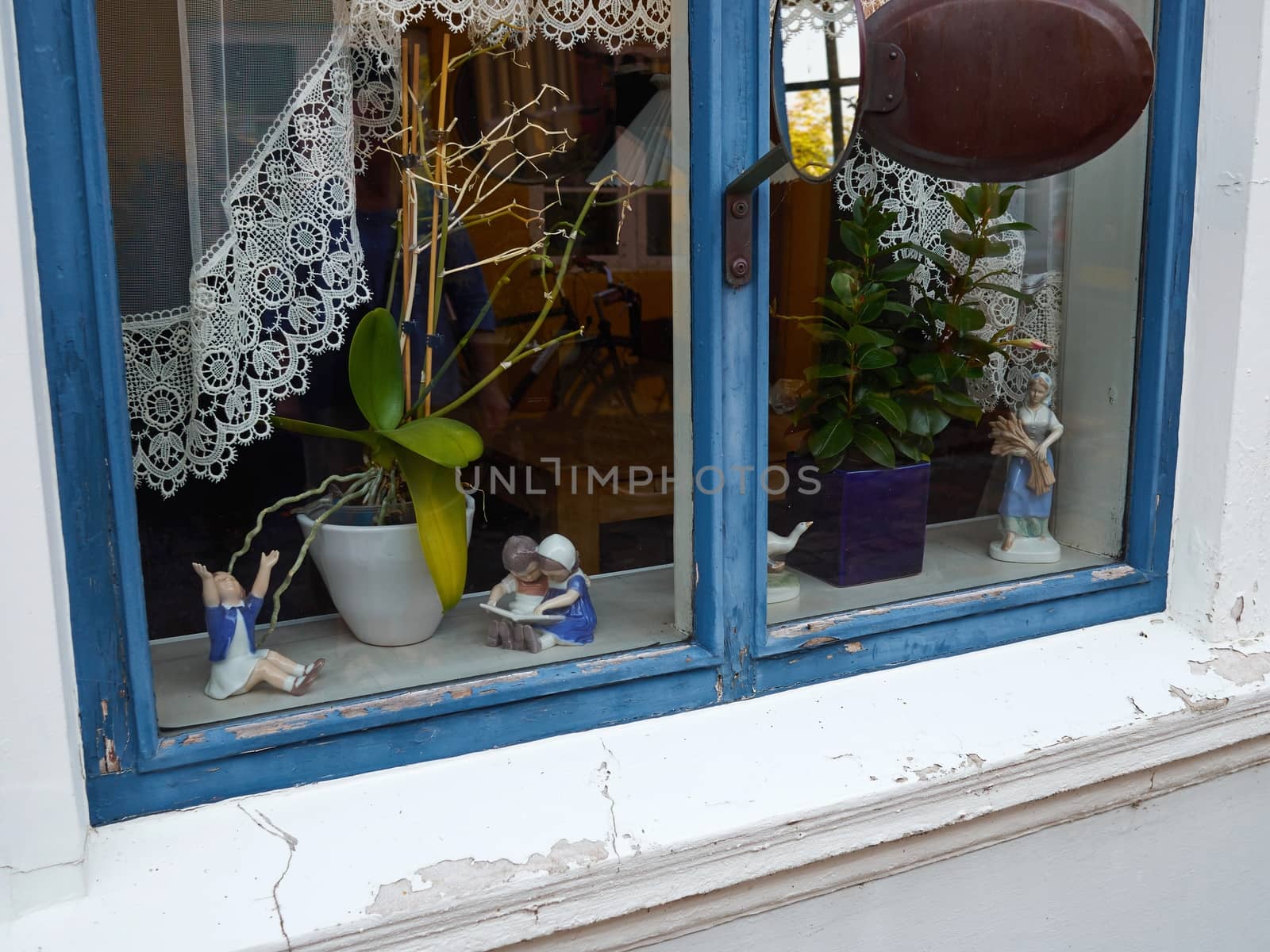 Classical vintage handmade European porcelain figurines in a window of a home